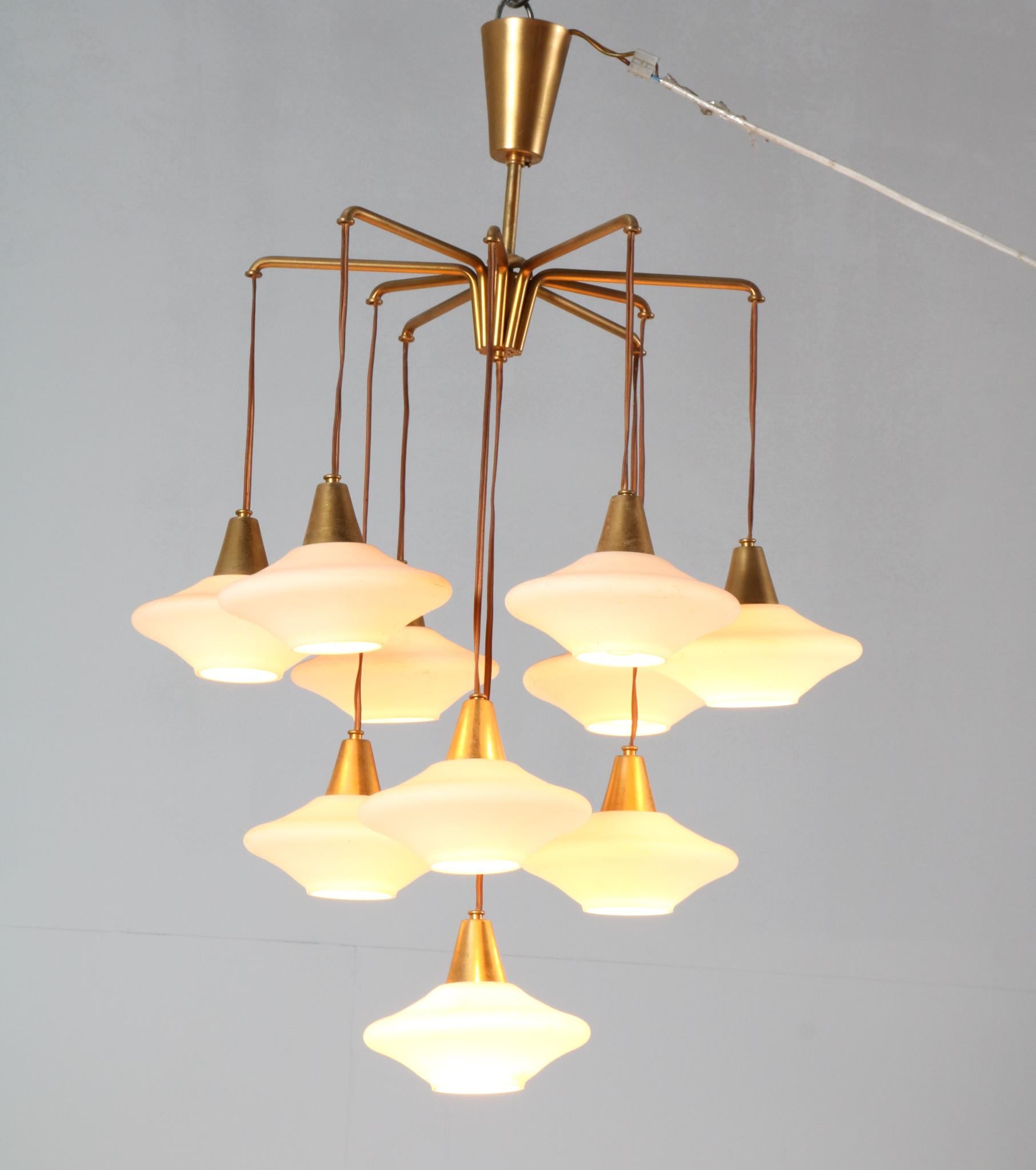Amazing and rare Mid-Century Modern chandelier or pendant light.
Striking Italian design from the 1960s.
Gilt brass frame with ten original milk glass shades.
Rewired with ten original sockets for E-27 light bulbs.
This wonderful Mid-Century