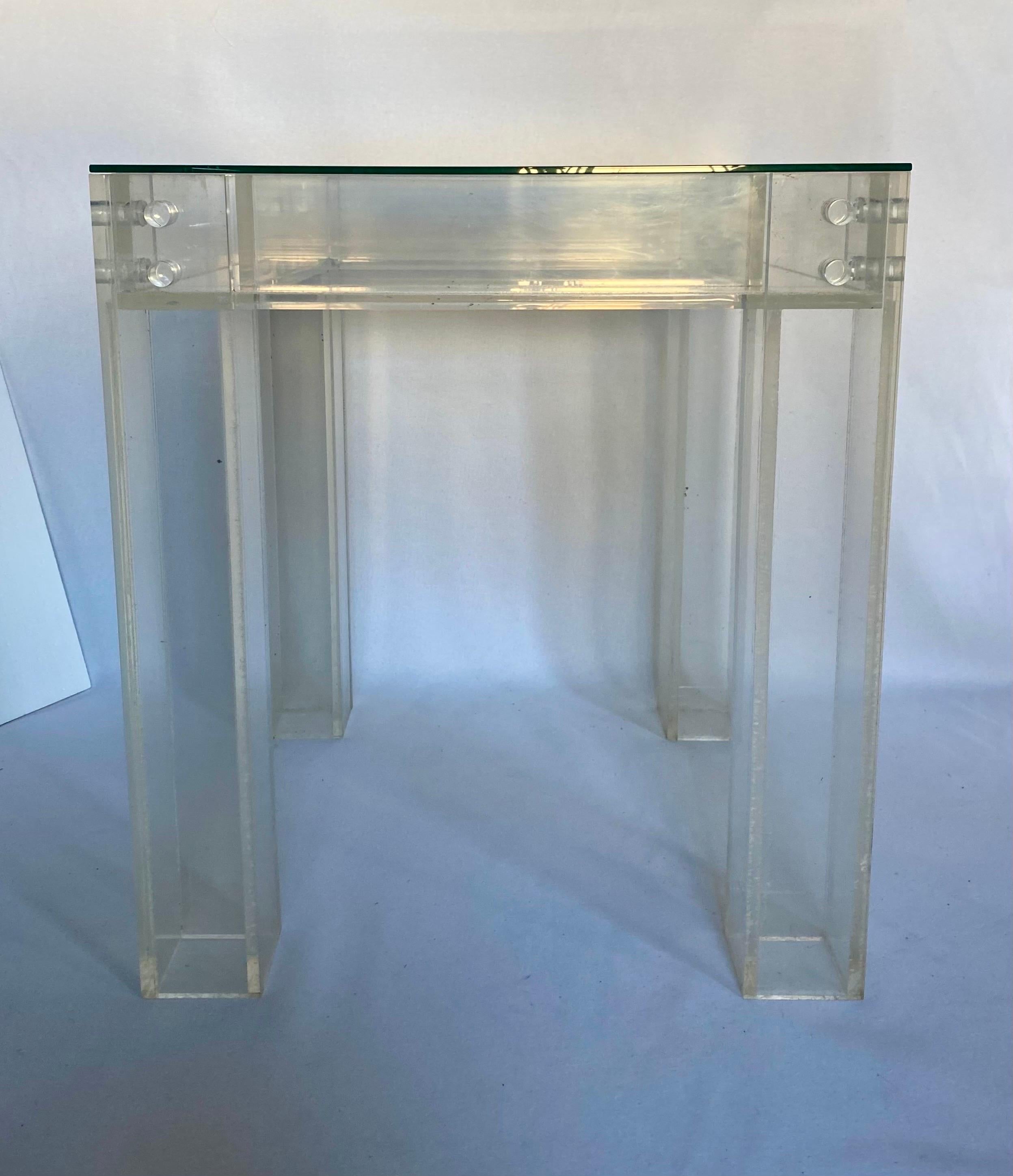 Mid-Century Modern square Lucite and glass side or end table in the style of Charles Hollis Jones. This dimensional table features a think double walled Lucite frame with a removable clear glass top and Lucite bolt hardware. Circa 1970's.