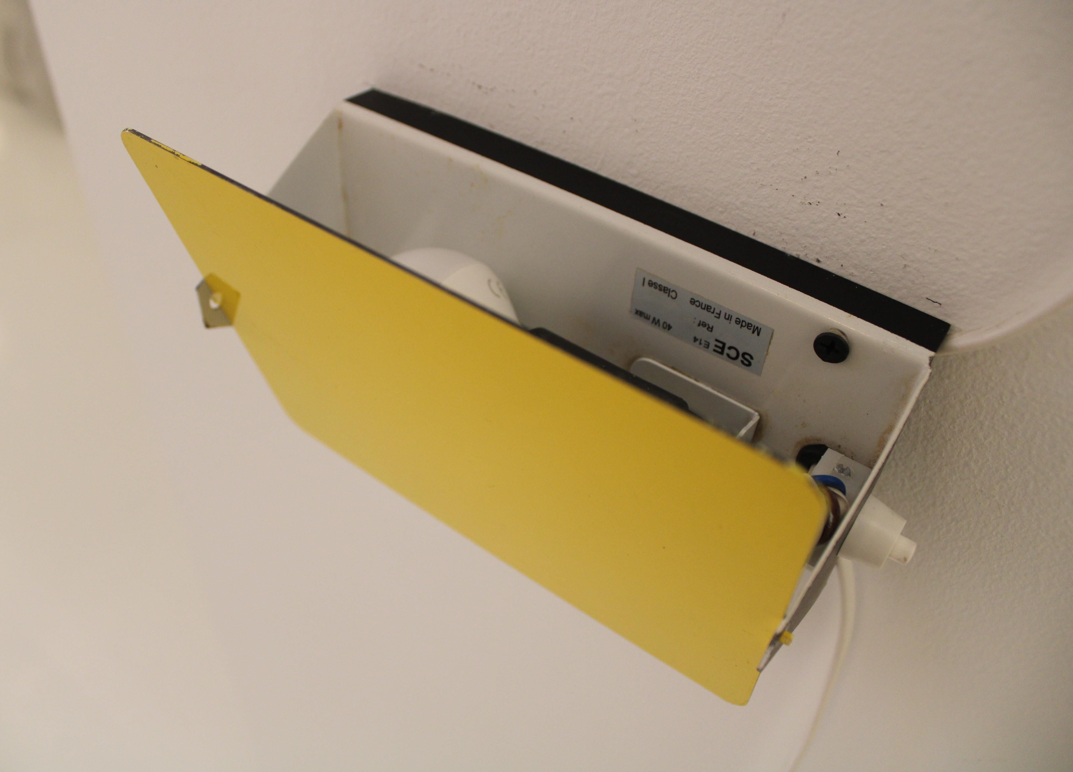 Ensemble de deux appliques jaunes conçues par l'emblématique Charlotte Perriand pour Steph Simon, vers 1960. Ces appliques murales modernes du milieu du siècle sont dotées d'une structure principale réglable, qui permet de rediriger la lumière de