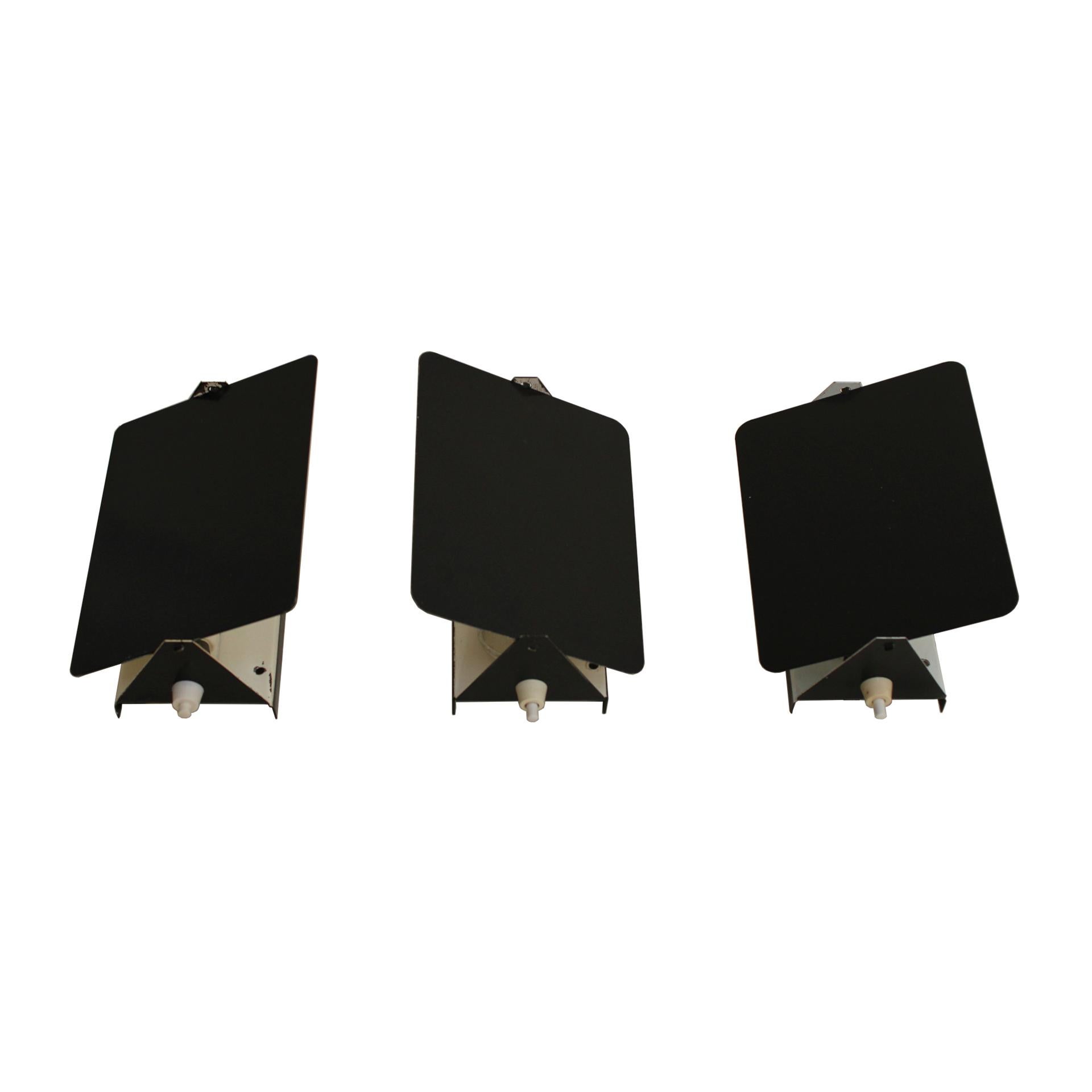 Set of three sconces mod. CP1 designed by Charlotte Perriand for Steph Simon, circa 1960. Composed of adjustable main structure to redirect the light. Made of black and white lacquered metal. With its original pattina.
      
