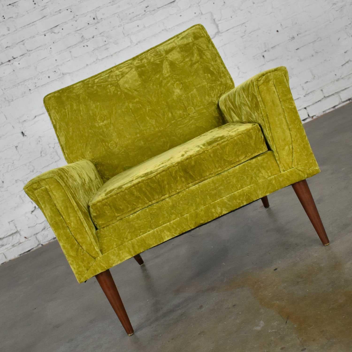 Gorgeous Mid-Century Modern chartreuse crushed velvet club chair or lounge chair in the style of Paul McCobb. Comprised of angled tapered wooden legs, brass colored metal feet, and it’s wearing its original chartreuse crushed velvet fabric with 4
