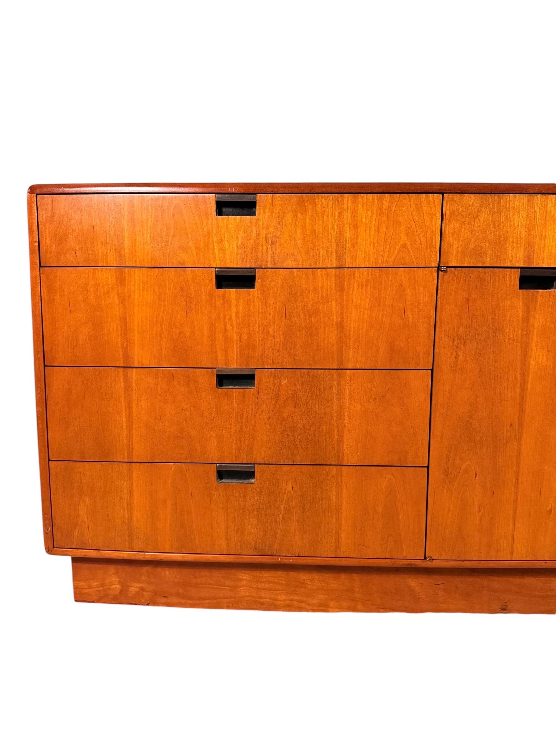 Questa elegante credenza moderna di metà secolo di Dunbar Furniture esemplifica la rinomata abilità artigianale e il design senza tempo del marchio. Rifinito in elegante legno di ciliegio, le sue linee pulite e la sua sobria eleganza lo rendono
