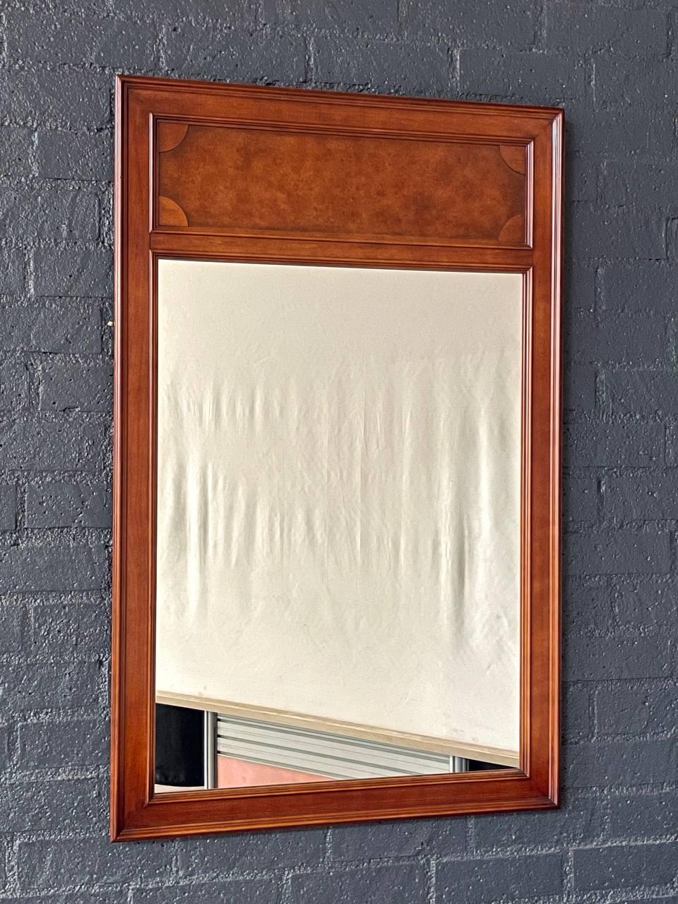 Condition: Original Vintage Condition 
Materials: Cherry Wood, Original Mirror

This Mid-Century Modern wall mirror from the 1960s showcases a beautifully crafted cherry wood frame with clean lines and subtle detailing that highlight its timeless