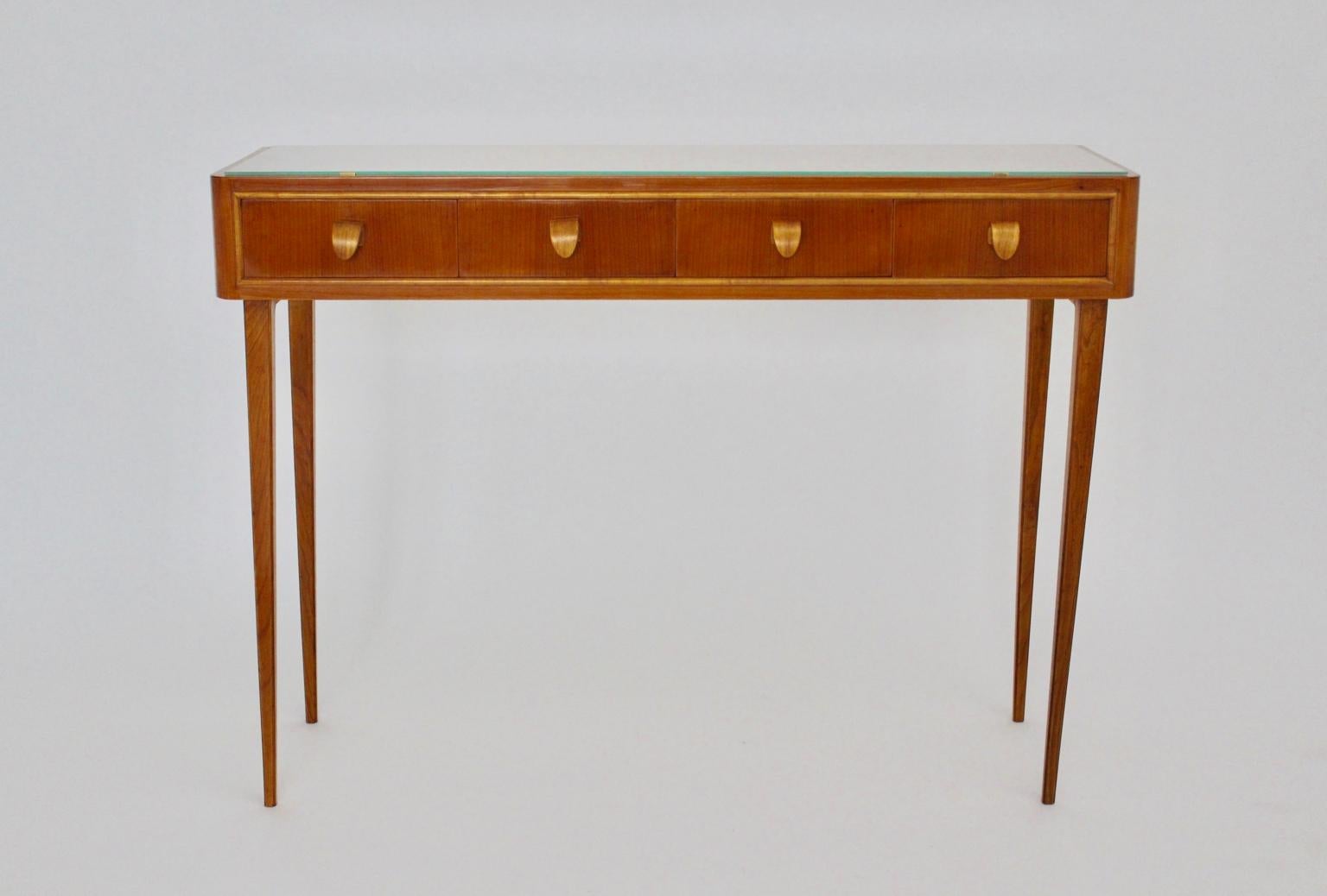 Mid century modern vintage commode or sideboard from cherry wood designed and executed Italy 1950s.
The wonderful sideboard or commode shows solid cherry wood, maple tree veneer, plywood, fibre board and brass details.
Honey brown cherry wooden tone