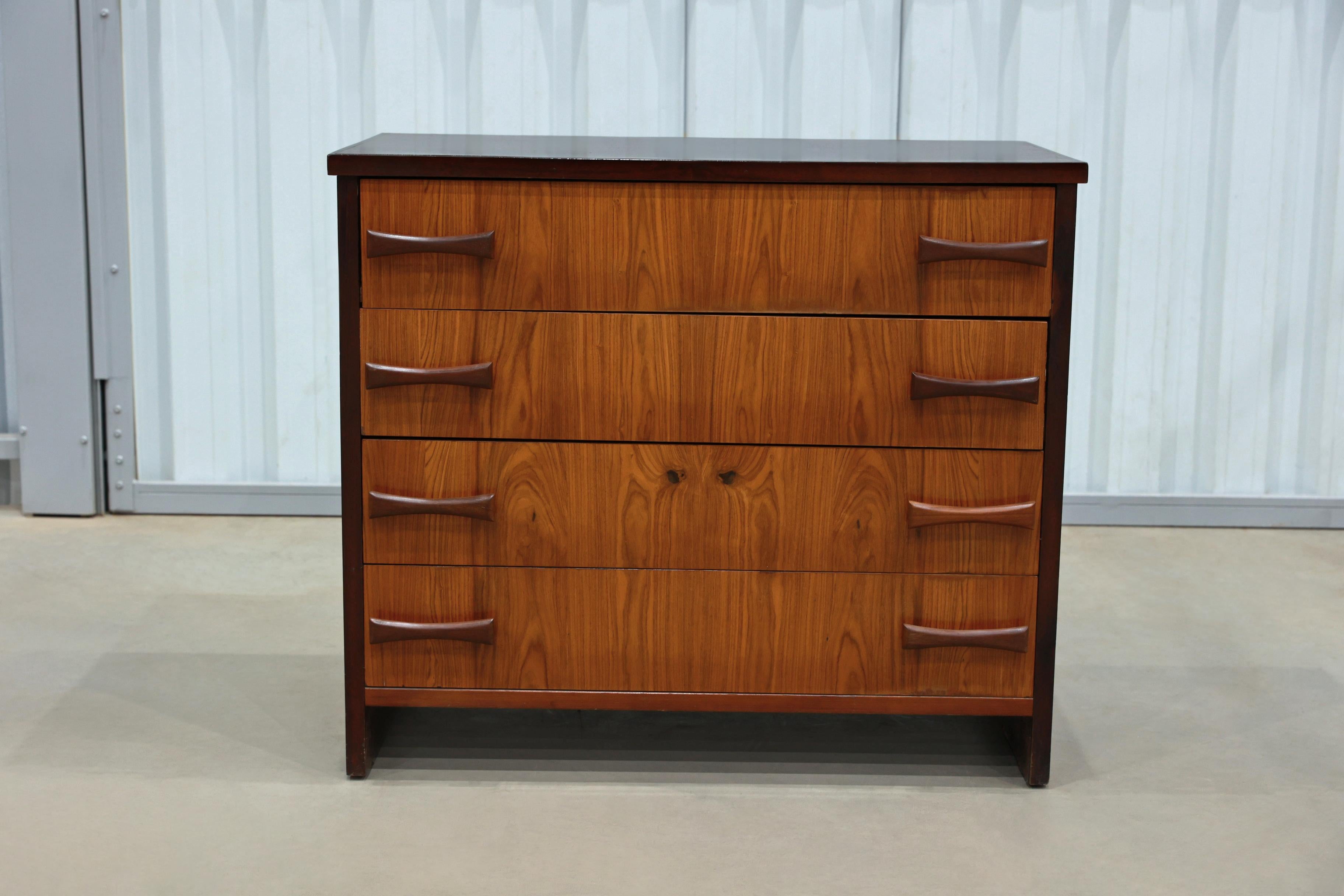 This chest of drawers is made in Caviuna wood and features four pull-out drawers with wooden handles on each side. The wood on this piece has a beautiful color and pattern and has been refinished to be in excellent condition. If you are looking for