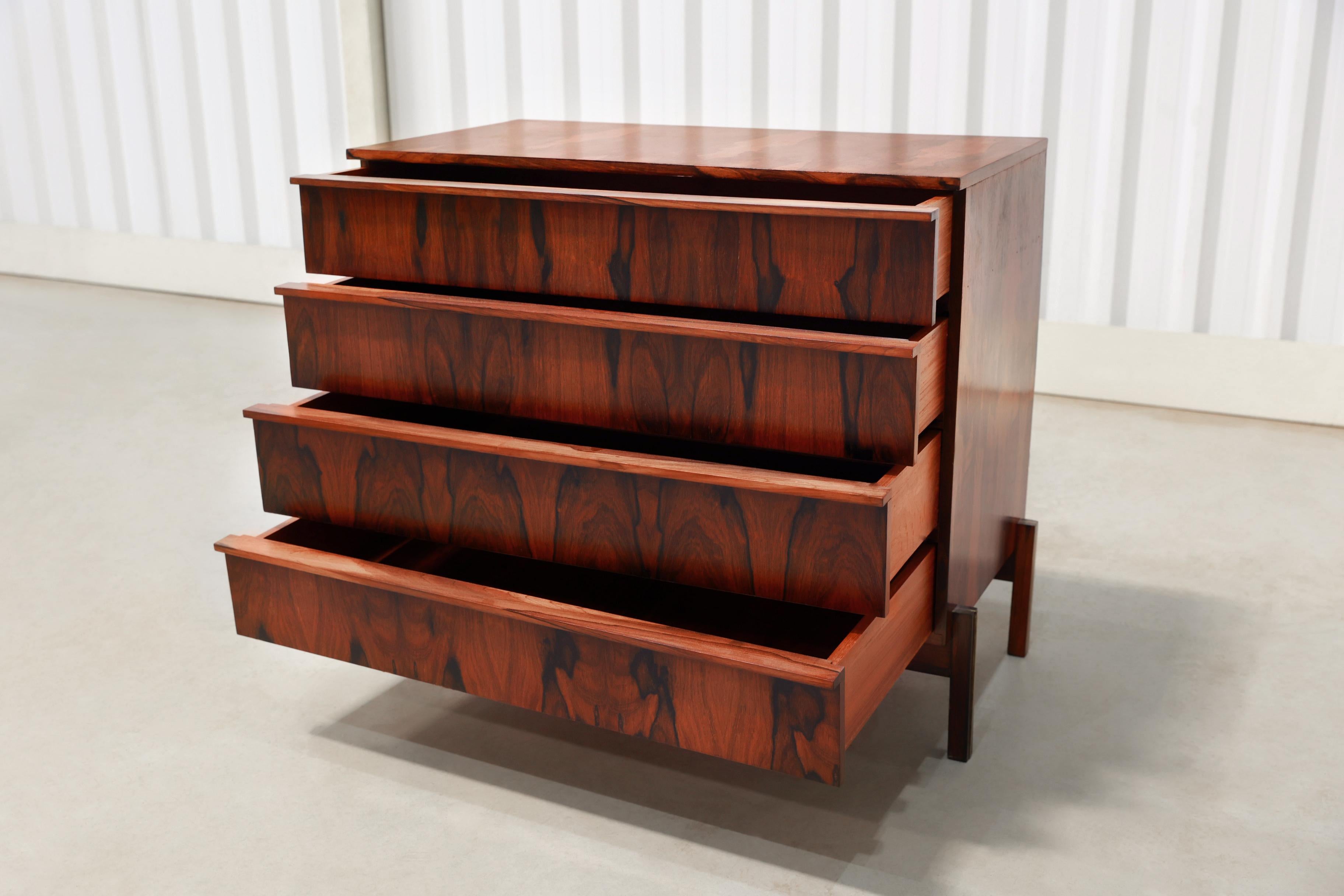 Beautiful chest of drawers in Brazilian Rosewood (known as Jacaranda) and Rosewood veneer. It consists of 4 drawers resting in four delicate legs. What makes this piece are the wood patterns displaying colorful veins. This gorgeous piece is