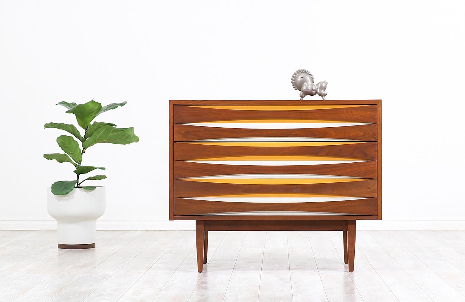 Stylish Mid-Century Modern chest designed and manufactured by West Michigan Furniture Co. in the United States, circa 1950s. This sleek chest design with a classic take on the style of Arne Vodder, features three dovetailed drawers and a walnut wood