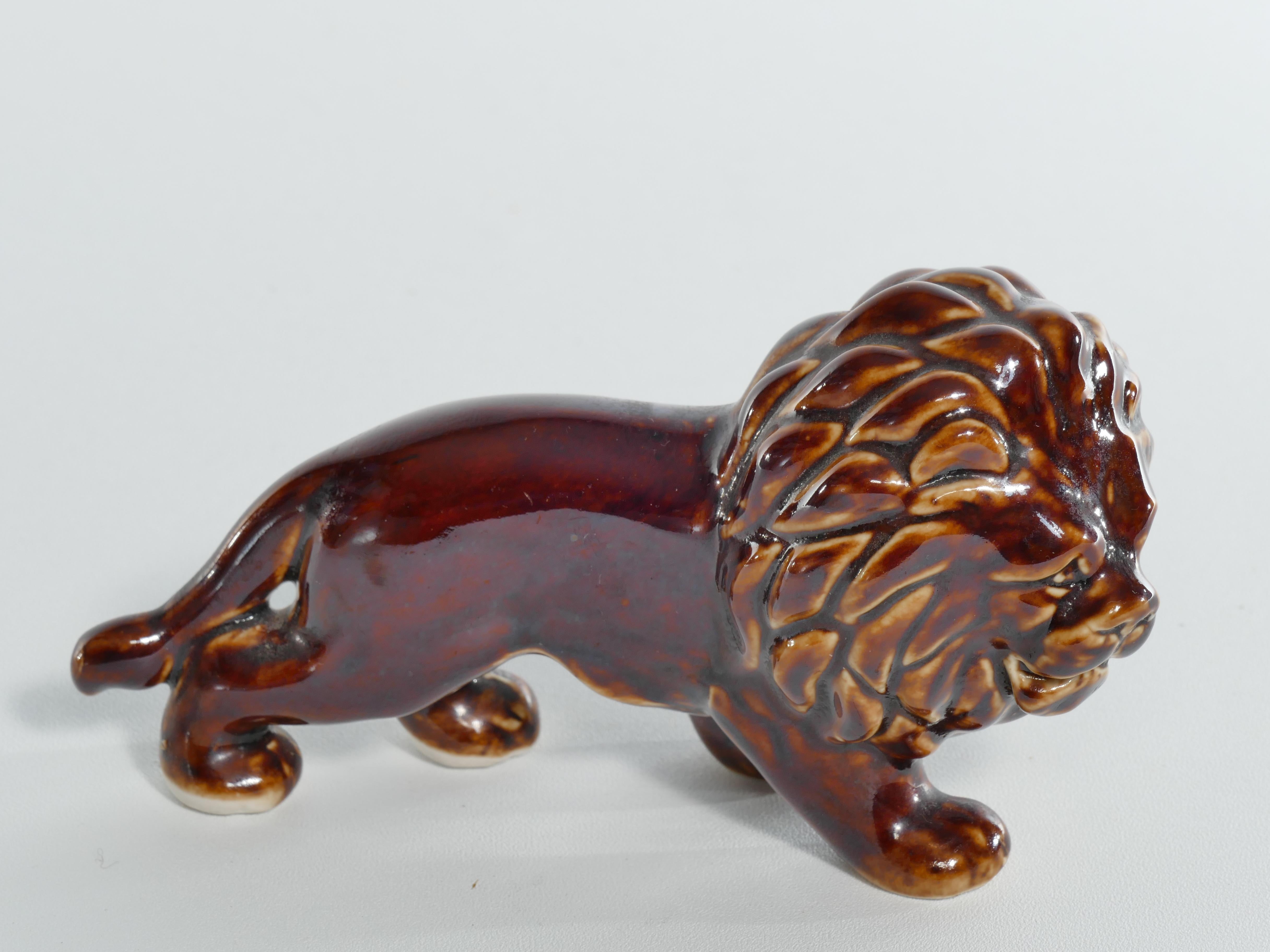 Nice anatomy in high gloss brown glaze. Detailed lion mane, face with good proportions. The lustrous brown glaze adorning the surface adds depth and character, reflecting the play of light.

The lion, a symbol of strength, protection, and power in
