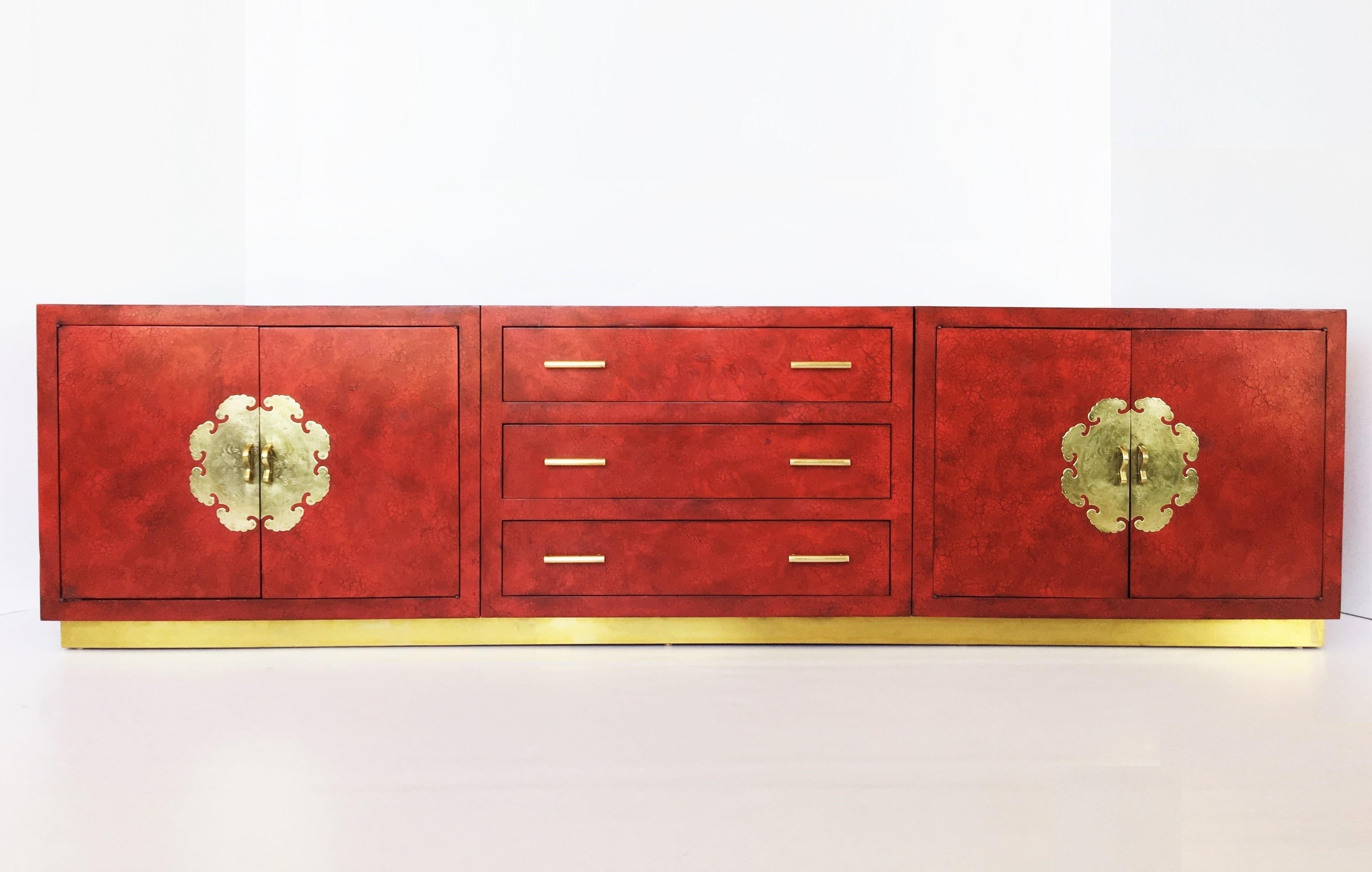 This stunning exceptionally sized sleek credenza or sideboard, channeling old Hollywood with a touch of the orient. Made of solid wood, featuring a custom lacquer finish. Three wide central drawers flanked by pair of cabinet doors adorned with