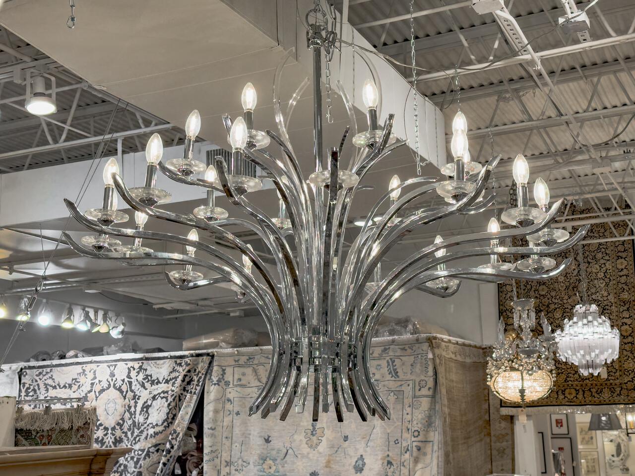 Elevate your space with timeless elegance and striking illumination courtesy of this Large Mid Century Modern Chrome Chandelier. With its sleek chrome finish and minimalist design, this chandelier embodies the essence of mid-century modern