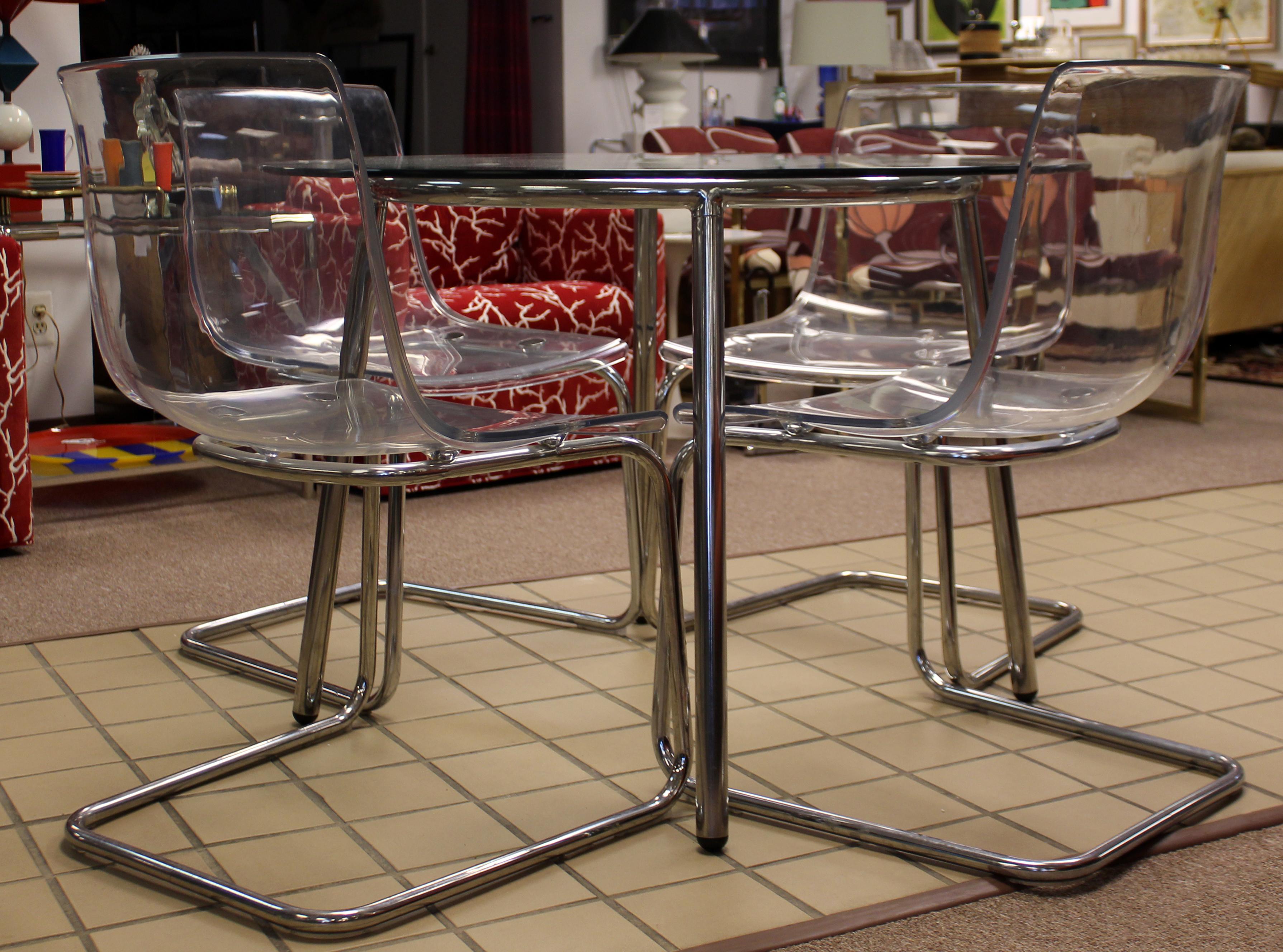 For your consideration is a fabulous dinette set, including four acrylic side dining chairs, and a round glass top and chrome table, circa 1970s. In excellent vintage condition. The dimensions of the table are 41