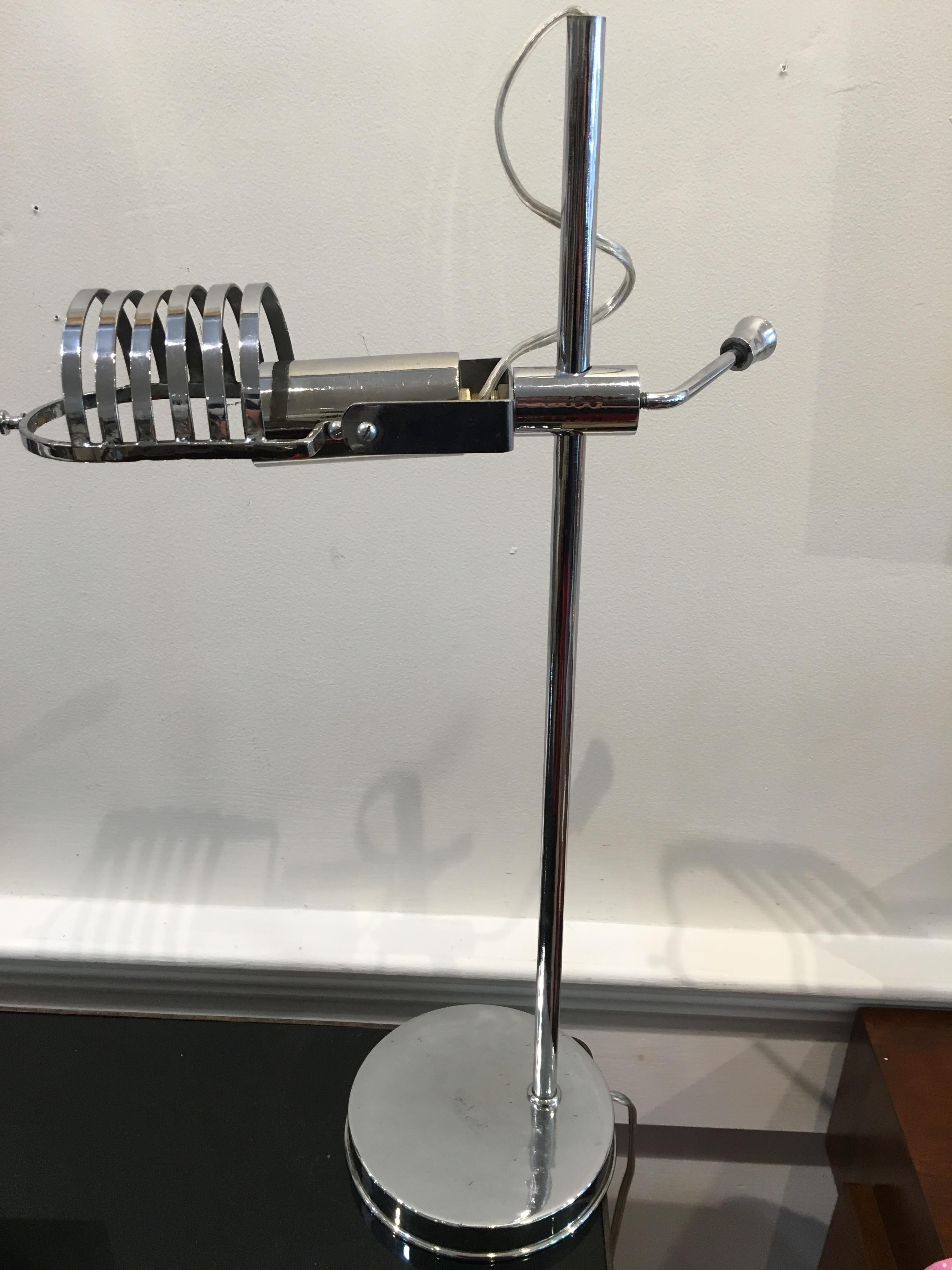 Mid-Century Modern chrome desk light. It adjusts up and down using the lever and the open work shade portion tilts up and down. It takes a European base bulb, which are easy to find. Rewired for American use. Very sculptural yet practical. Base
