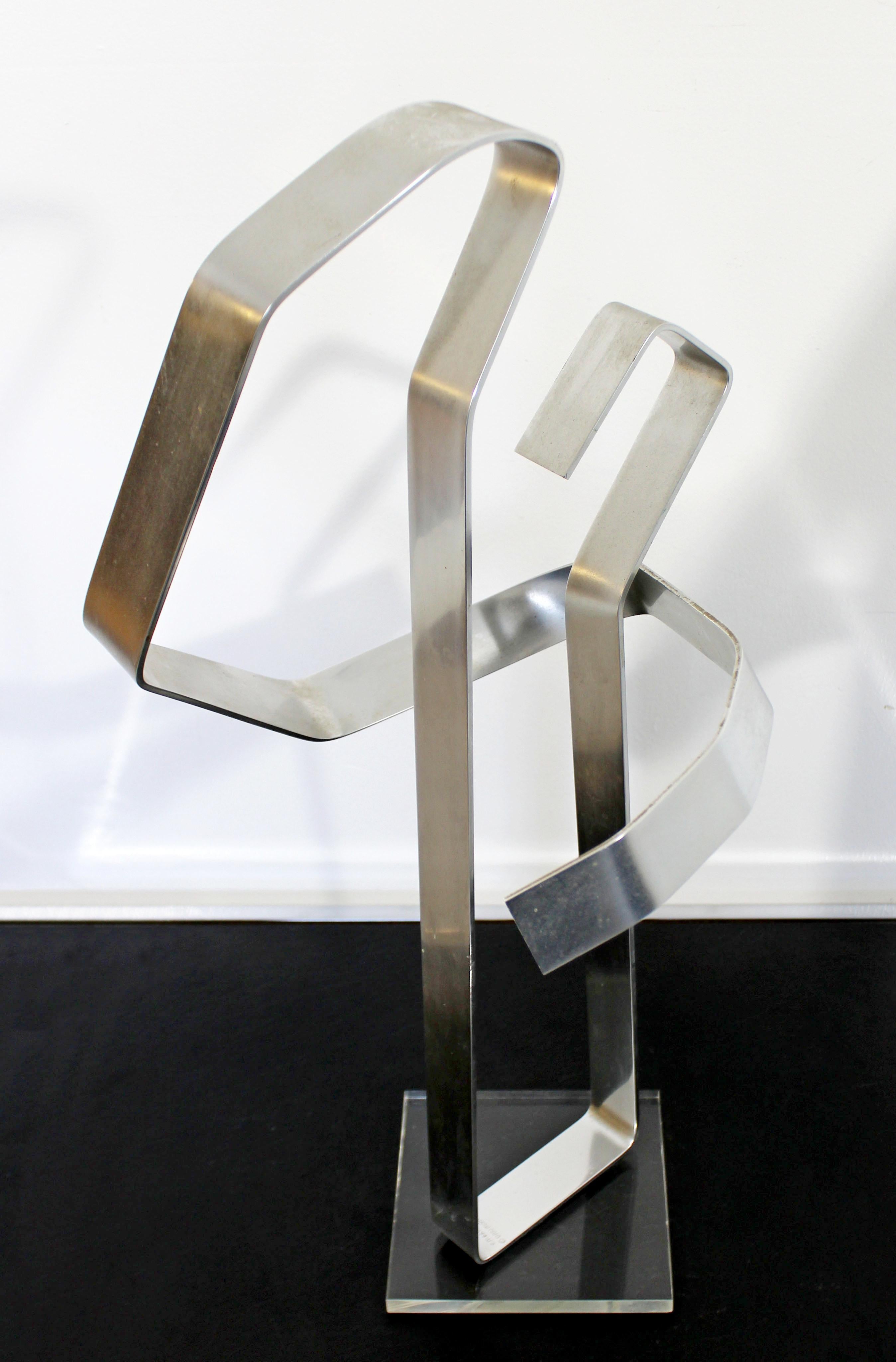 For your consideration is a thought provoking, abstracted, chrome metal table sculpture on a Lucite acrylic base, entitled 