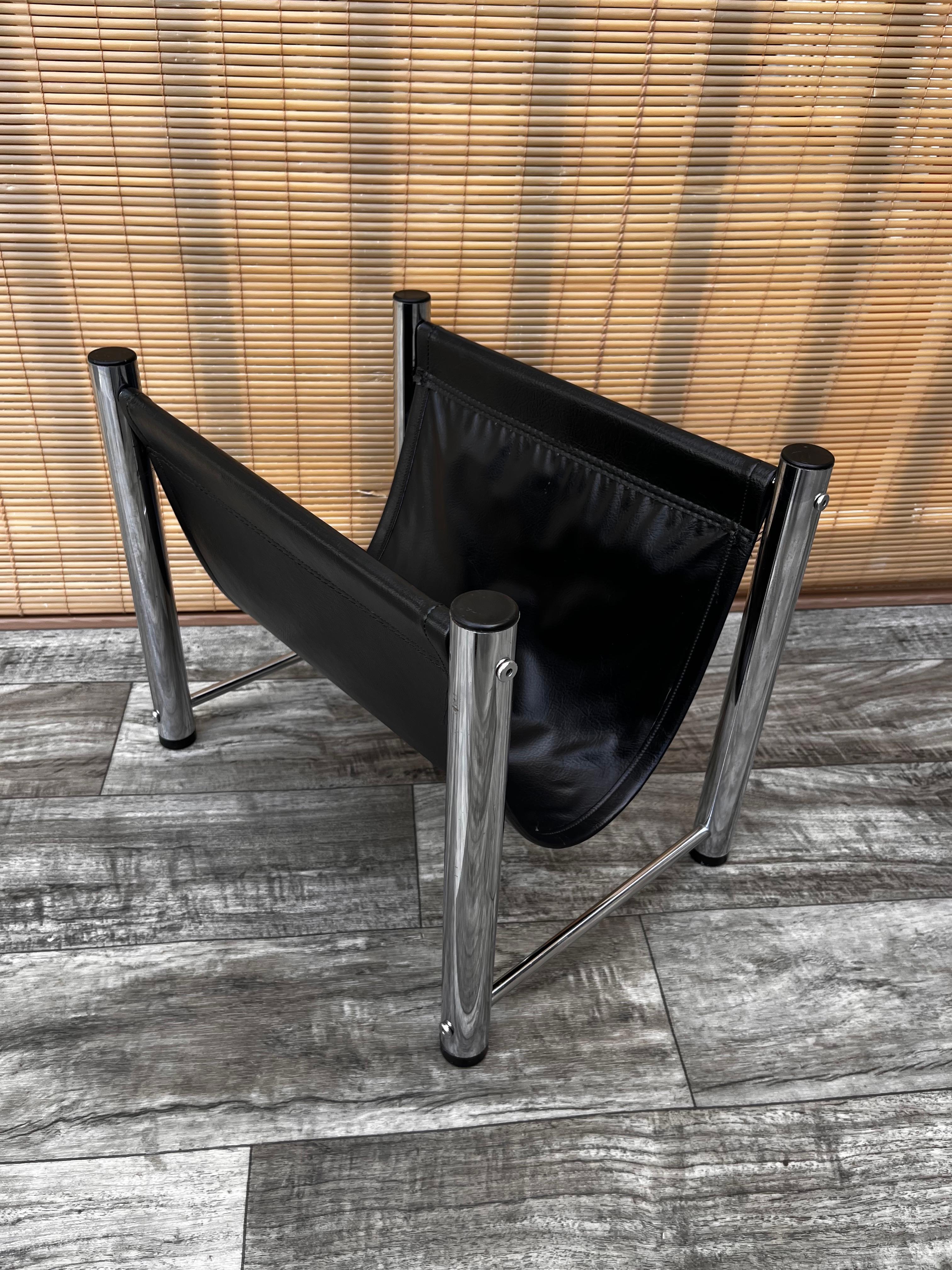 Vintage Mid-Century Modern chrome and black vinyl magazine rack in the Milo Baughman Style. C 1970s
Features a quintessential 1970s design with four tubular chrome legs and a black vinyl sling to hold the magazines.
In excellent near mint original