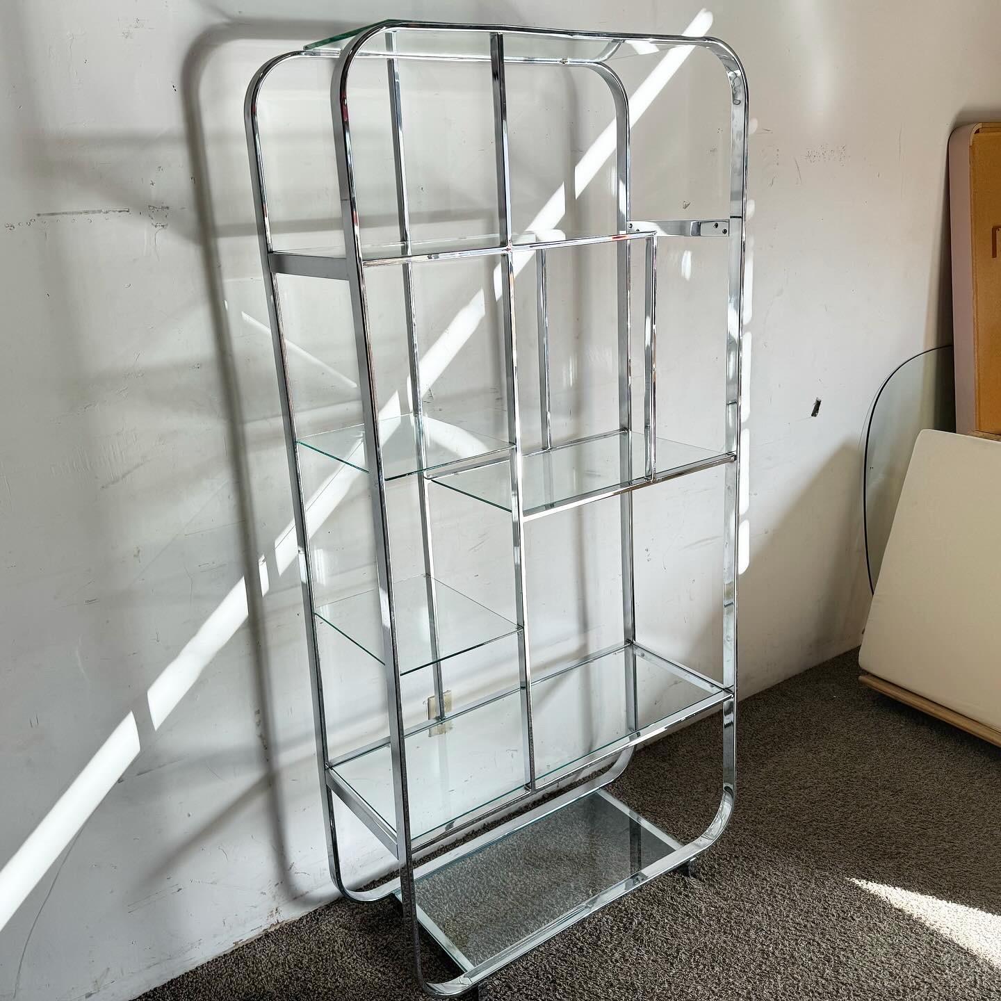 Elevate your decor with the Chrome Glass Etagere DIA, a Mid Century Modern masterpiece. This etagere combines a minimalist chrome frame with clear glass shelves, perfect for displaying books and collectibles. It embodies the sleek, clean lines of