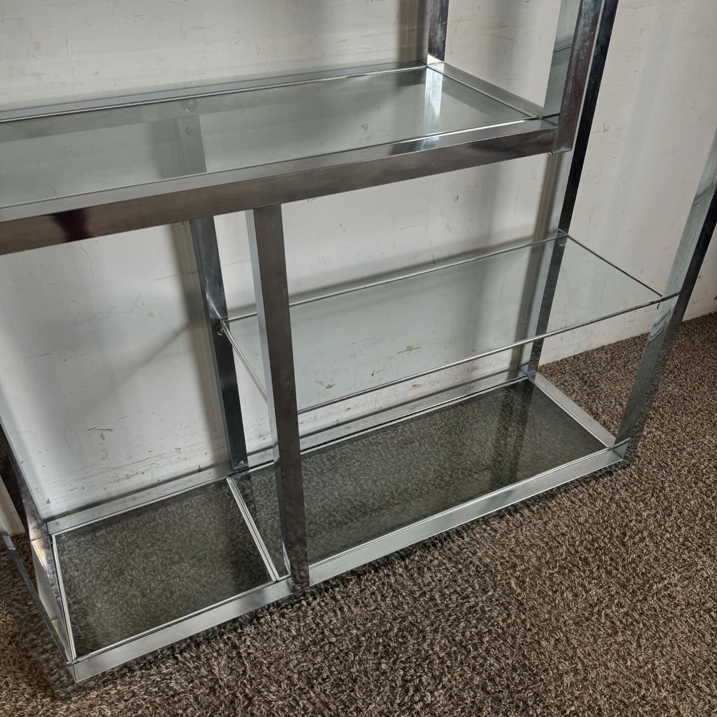 Introduce the timeless elegance of the Mid Century era to your space with this Mid Century Modern Chrome Glass Etagere. Featuring a minimalist chrome frame and multiple glass shelves, this piece offers a perfect blend of style and functionality. The