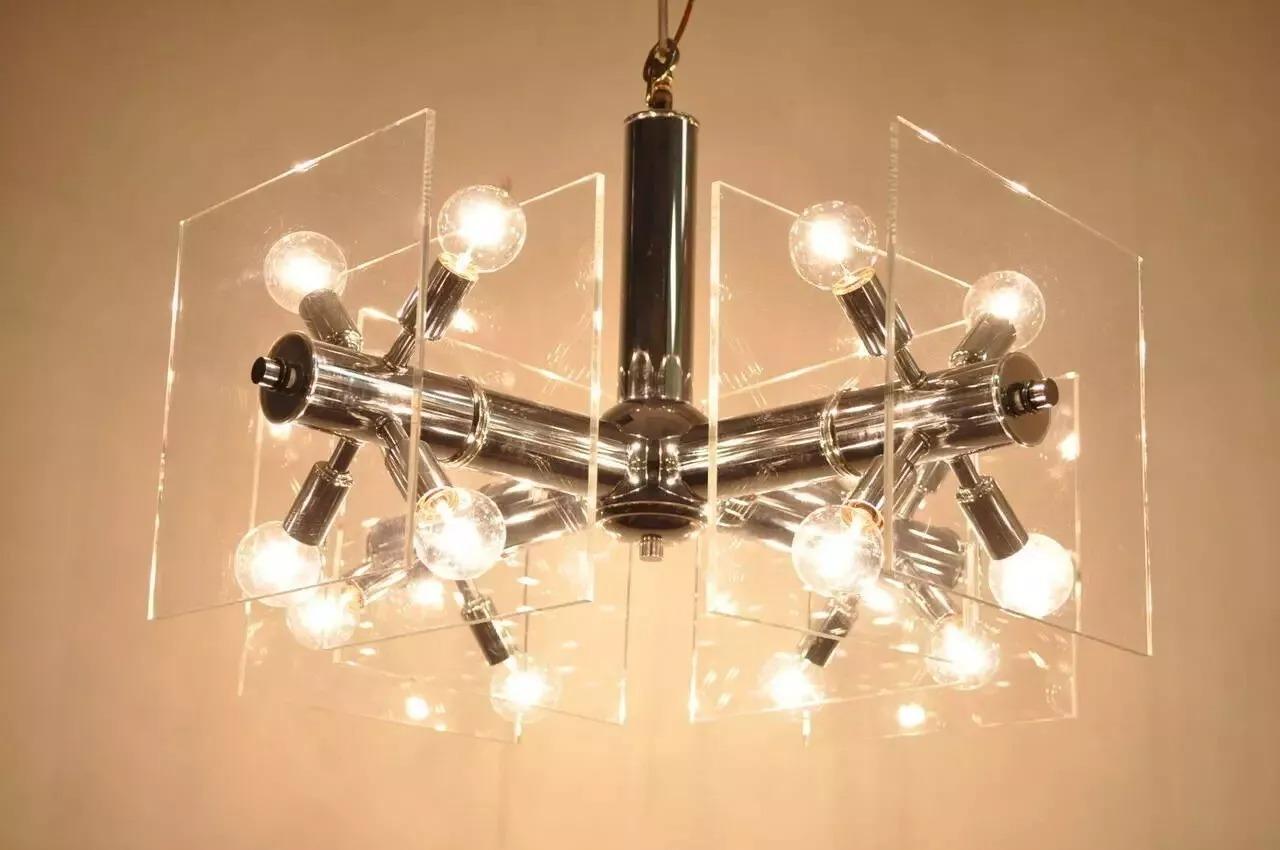 Lampadario Sputnik Modern d'epoca in cromo e lucite. L'articolo presenta una struttura cromata con finitura a specchio, quattro bracci con quattro luci per braccio che si estendono da prese in stile Sputnik. Ciascun braccio presenta due quadrati di