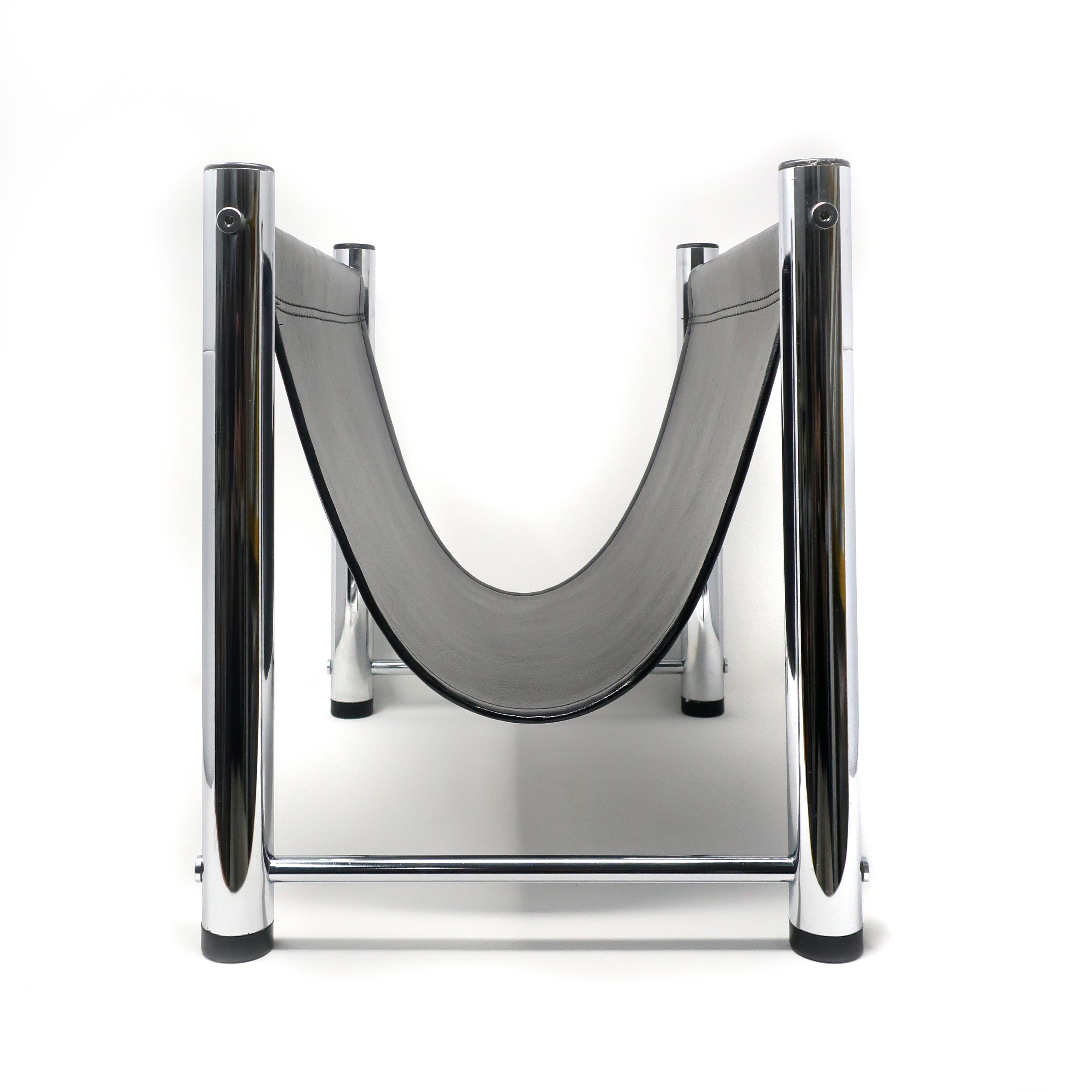 A Minimalist mod magazine rack designed with four tubular chrome legs and a black vinyl sling to hold magazine, books or firewood.

In very good vintage condition with scratches to one leg CAP.

Measures: 13