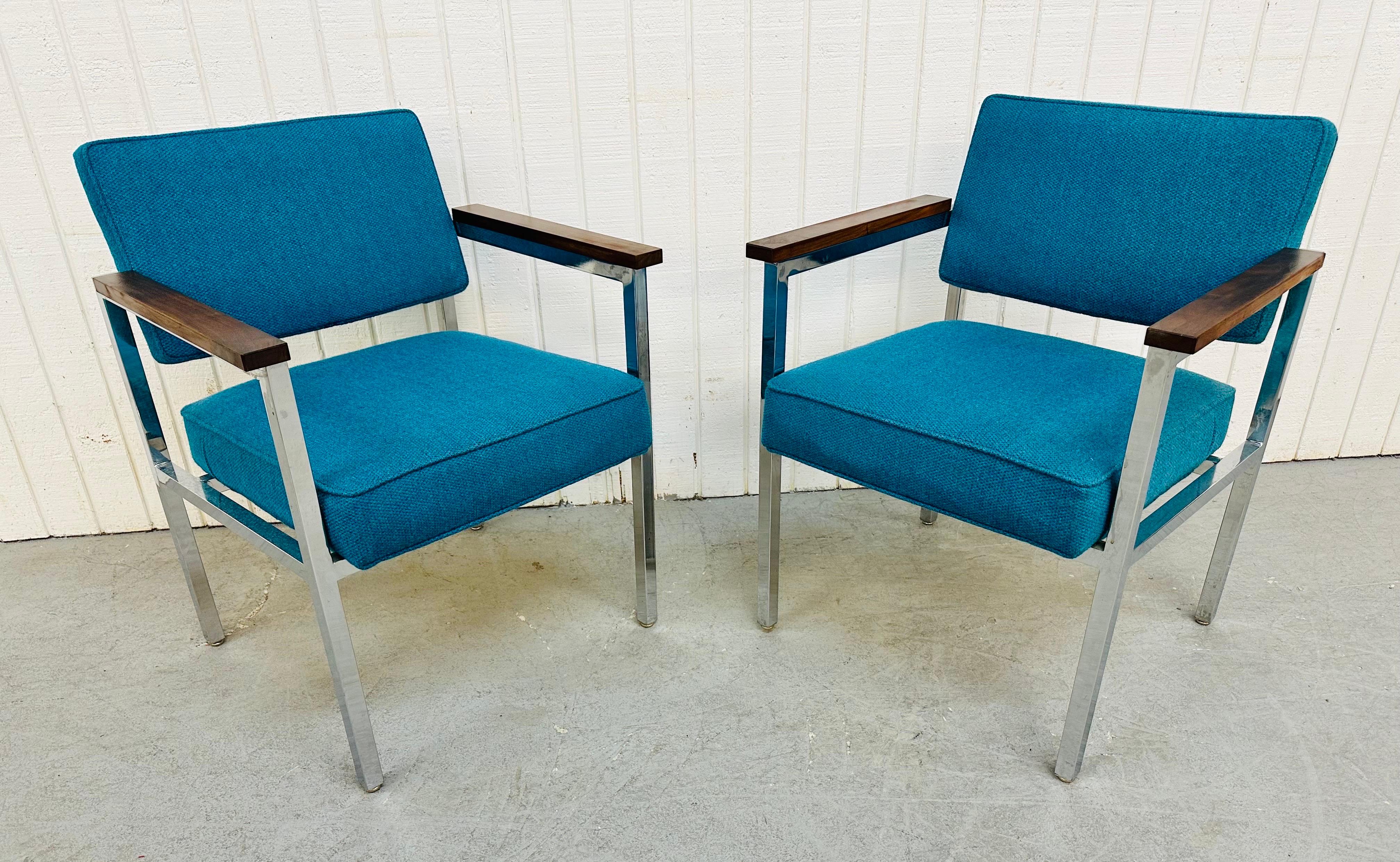 This listing is for a pair of Mid-Century Modern chrome armchairs. Featuring a chrome frame, walnut arm rests, beautiful blue upholstered seats and back rests. This is an exceptional combination of quality and design.