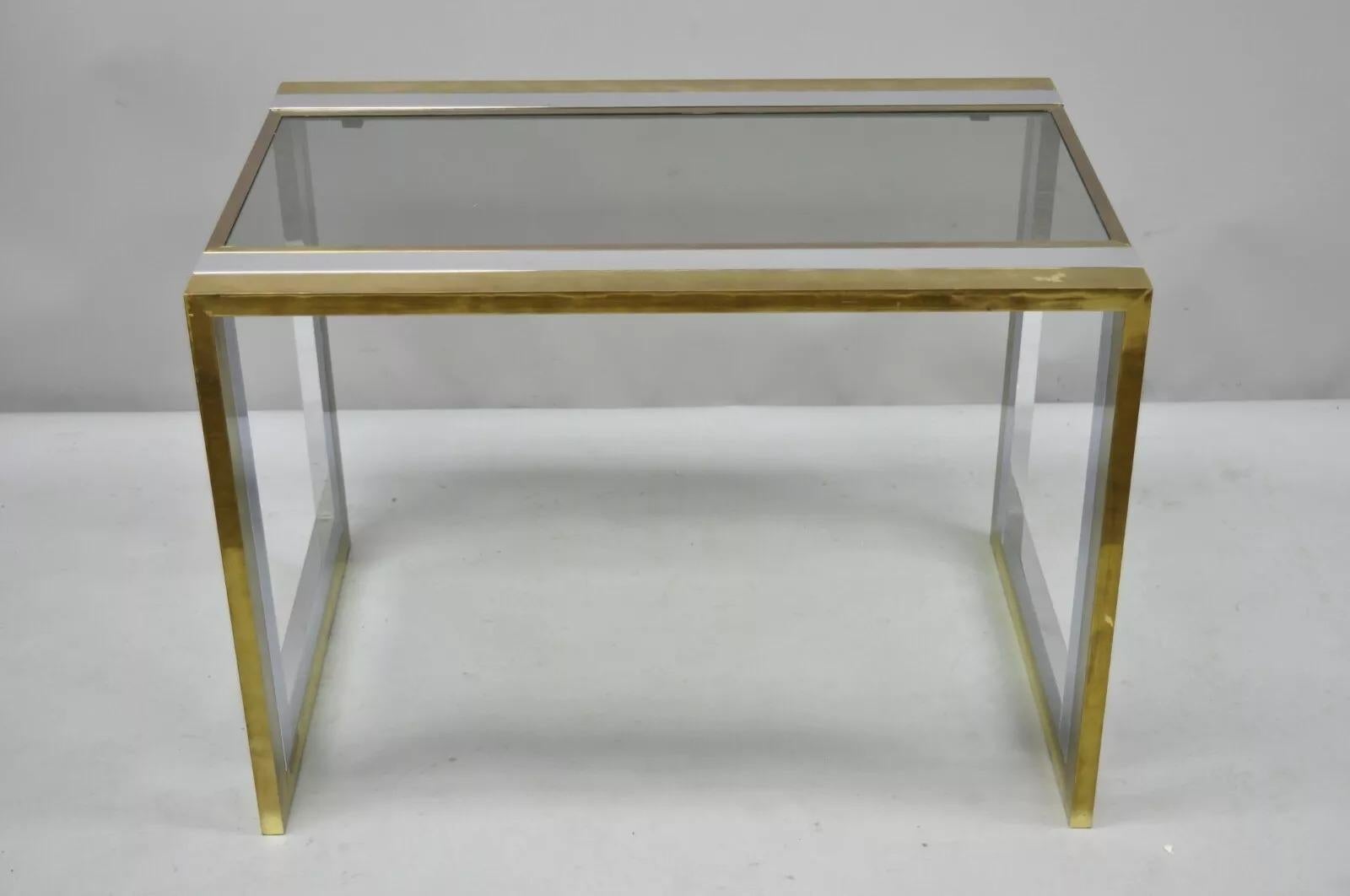 Vintage Mid Century Modern Chrome Brass Glass Waterfall Side Table by Messin Finland. L'article se caractérise par un cadre en cascade en chrome et en laiton, un plateau en verre, un Label original, des lignes modernistes épurées, une forme