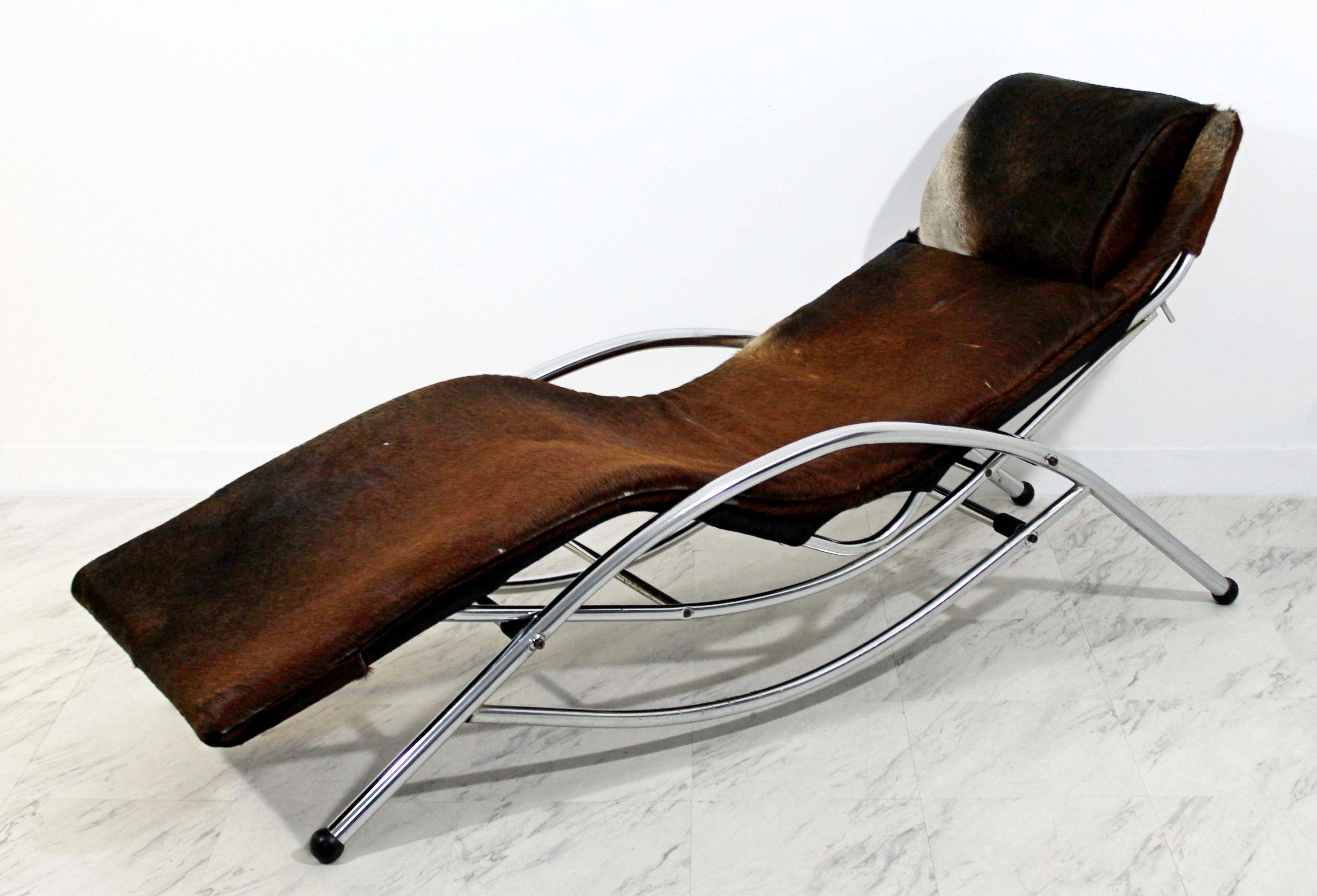 For your consideration is a fabulous, chrome chaise lounge, covered in brown cow hide, in the style of Le Corbusier, circa the 1970s. In excellent condition. The dimensions are 72