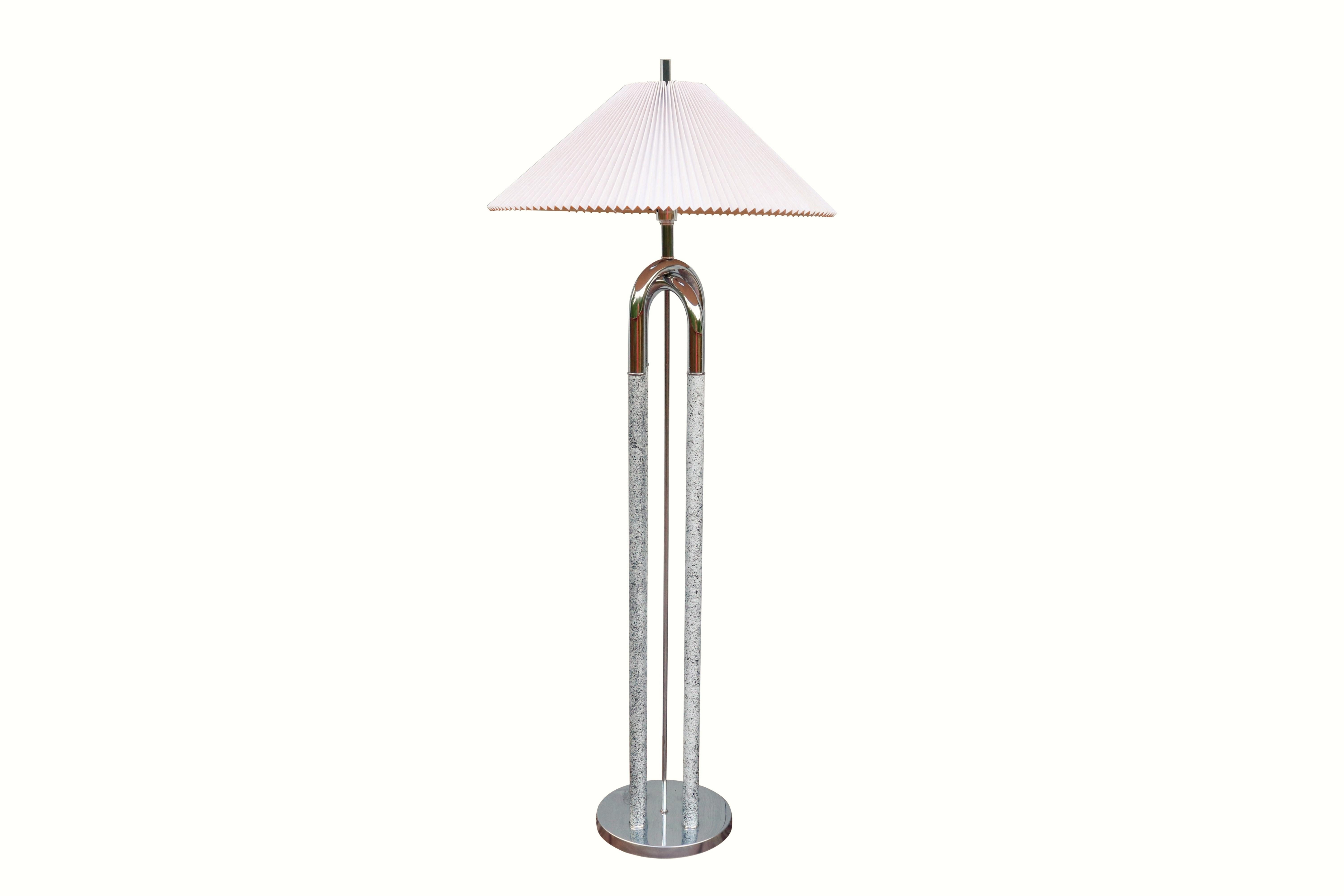 A Mid-Century Modern chrome four posted floor lamp. Posts stand on a round chrome base, are decorated with a black and white splatter pattern and connected at the top with chrome arches. Comes with a crimped shade and a lucite bar finial. Shade
