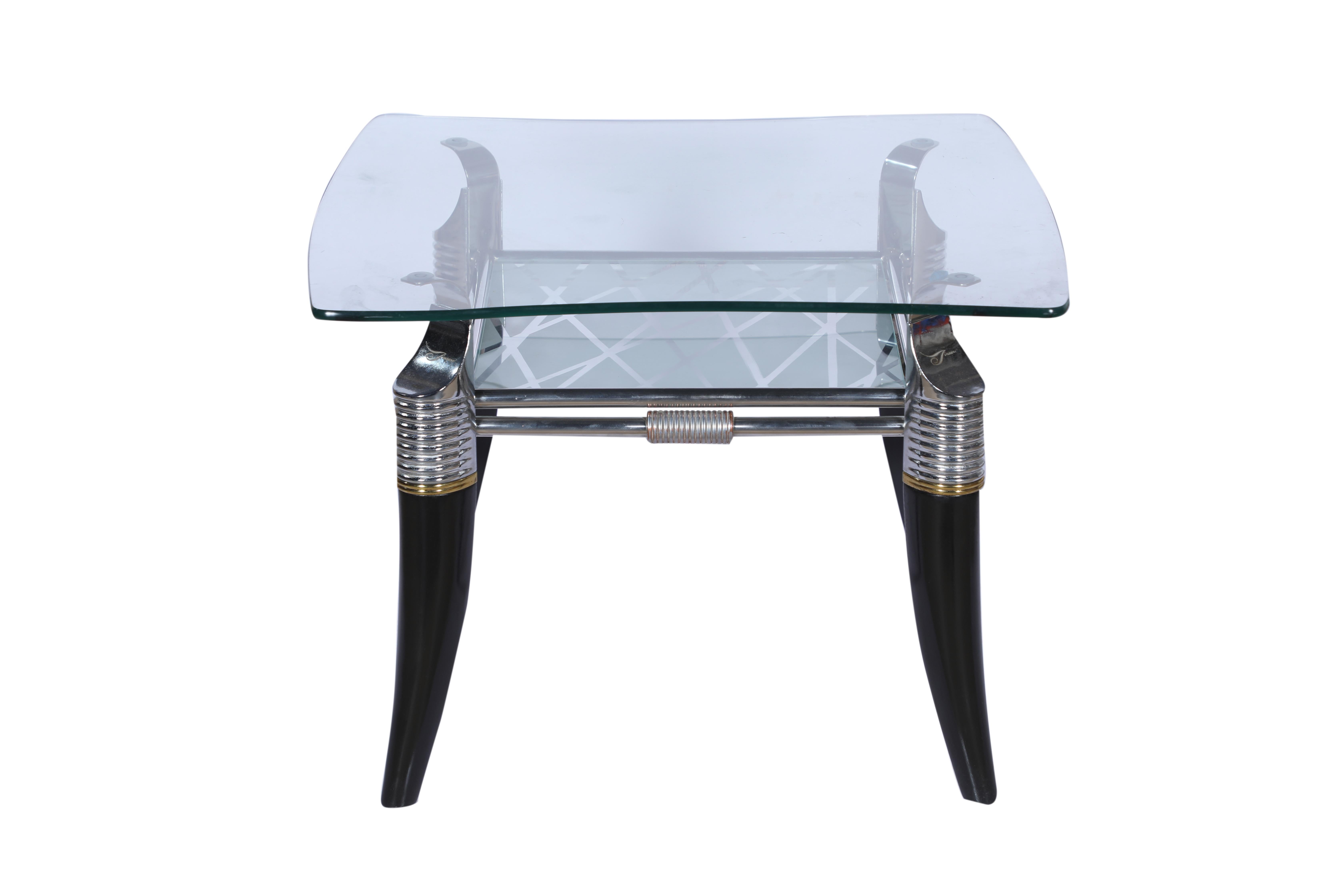 A very unusual Mid-Century Modern coffee or side table. It features ebonized legs in a faux horn motif, chrome detailing with a curved glass top and etched glass second shelf. As of this writing, there is a sister piece measuring 45 x 26. Together