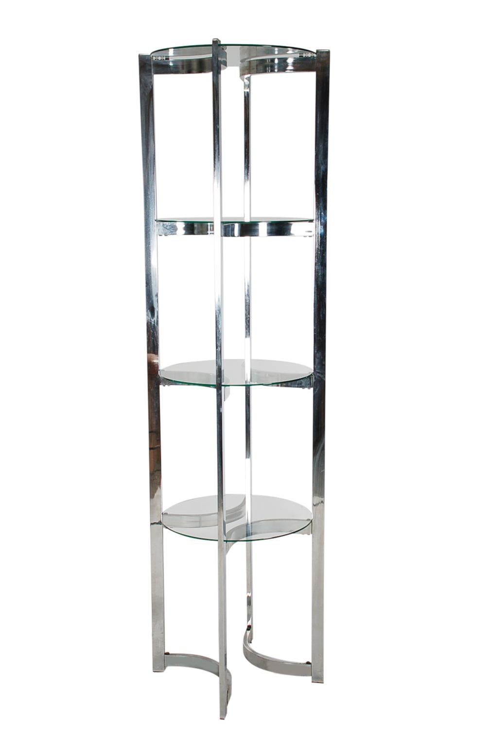 A circular étagère or corner shelving unit in the style of Milo Baughman from the 1970s. It features a chrome-plated steel structure with round clear glass shelves.