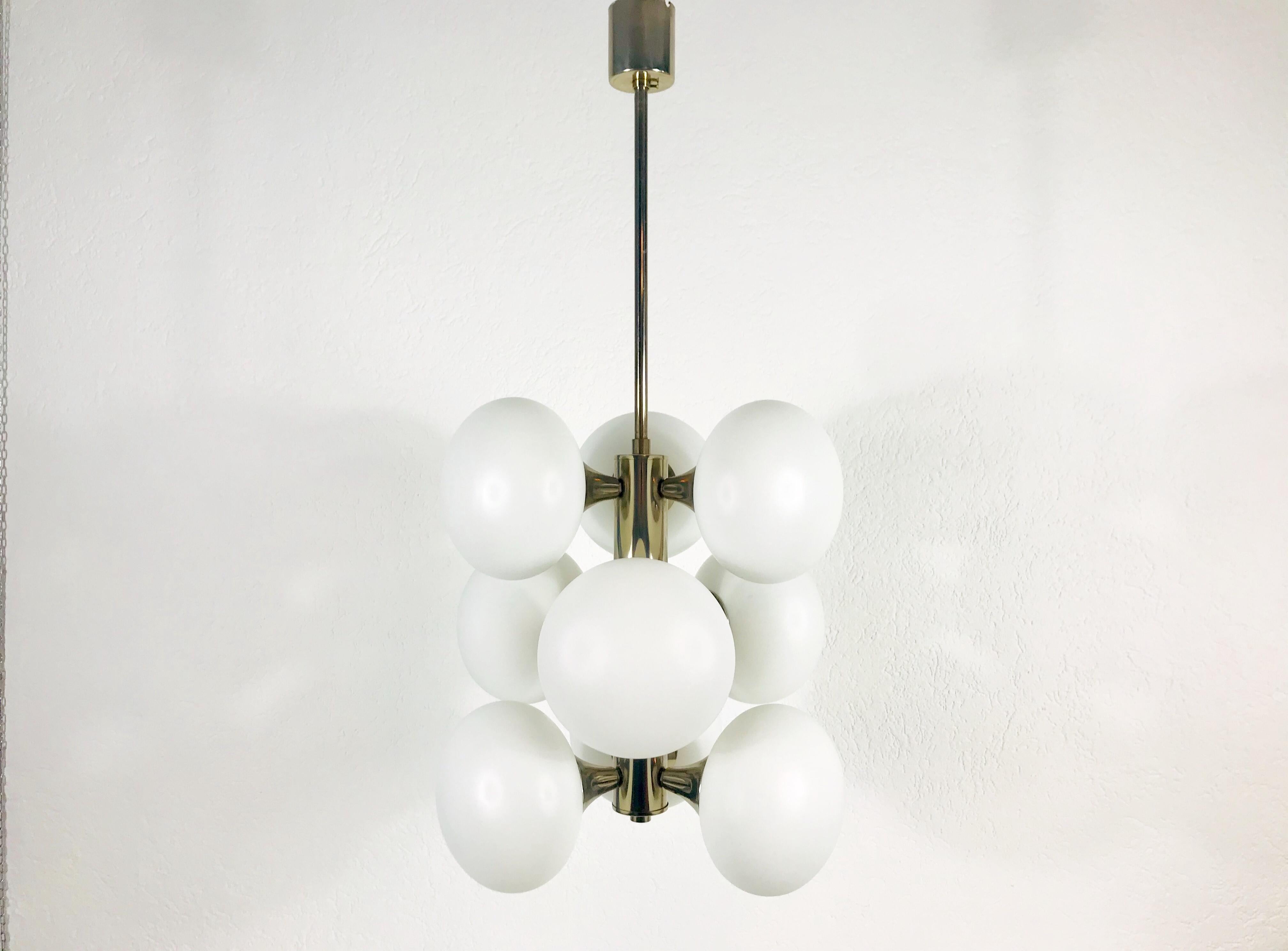 A midcentury chandelier made in Germany in the 1960s. It is fascinating with its Space Age design and nine opal glass balls. The body of the light is made of chrome metal, including the arms. 

The light requires nine E14 light bulbs.