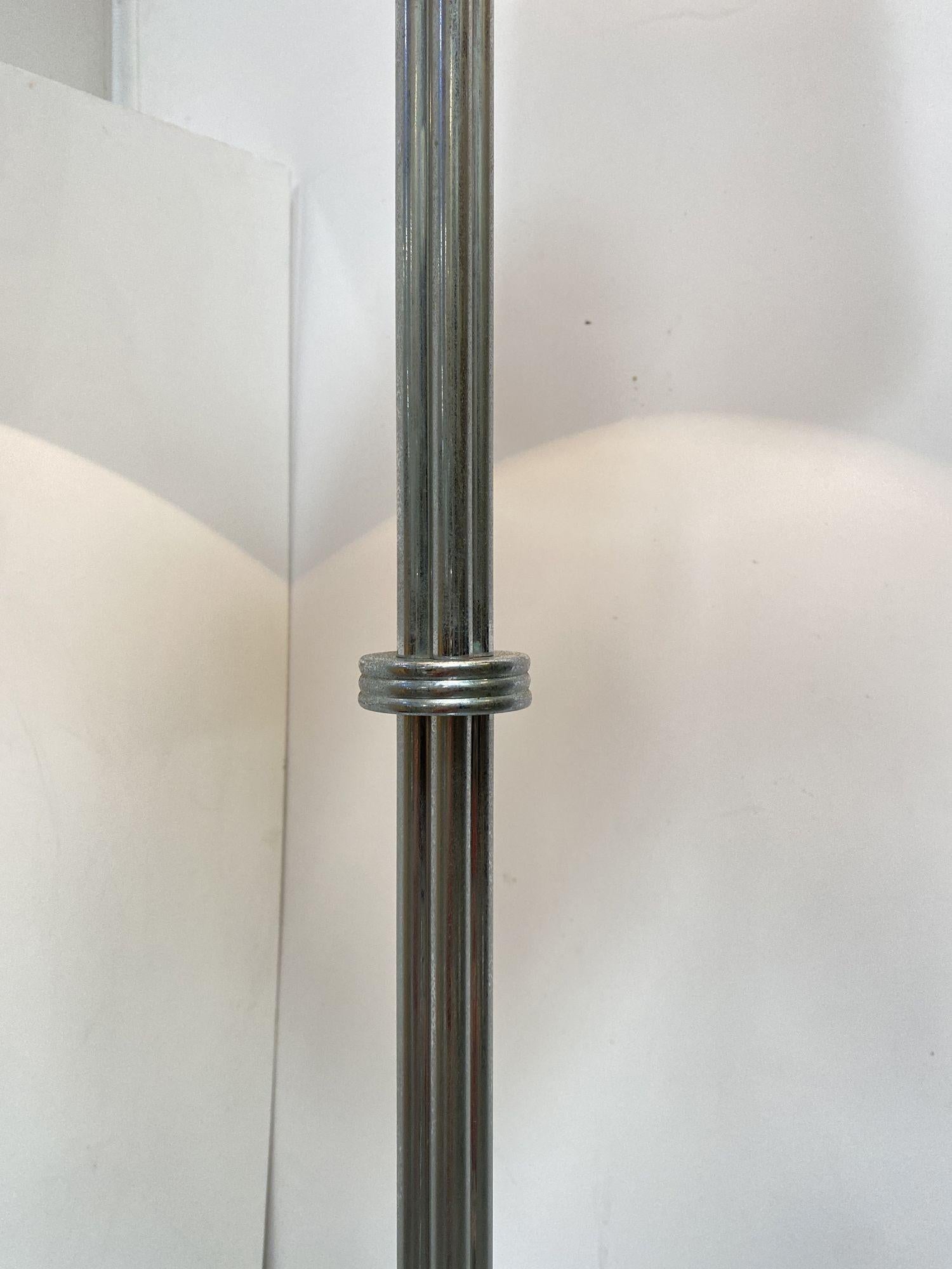 Mid-Century Modern chrome polish floor lamp made of 4 connecting rods flowing to ring base.