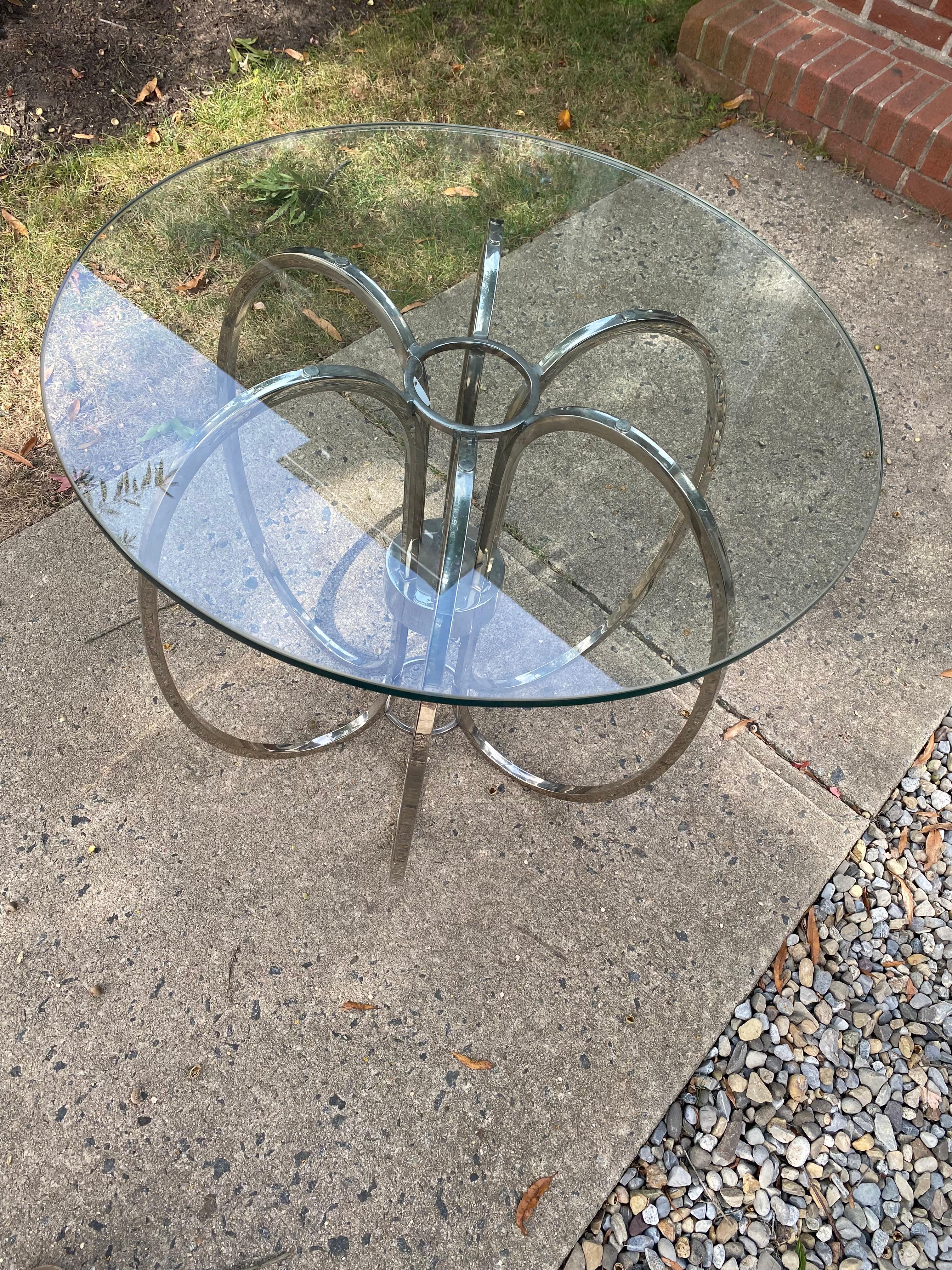 Eye catching side table featuring a sculptural loop ring chrome base with 1/2” thick round glass top.