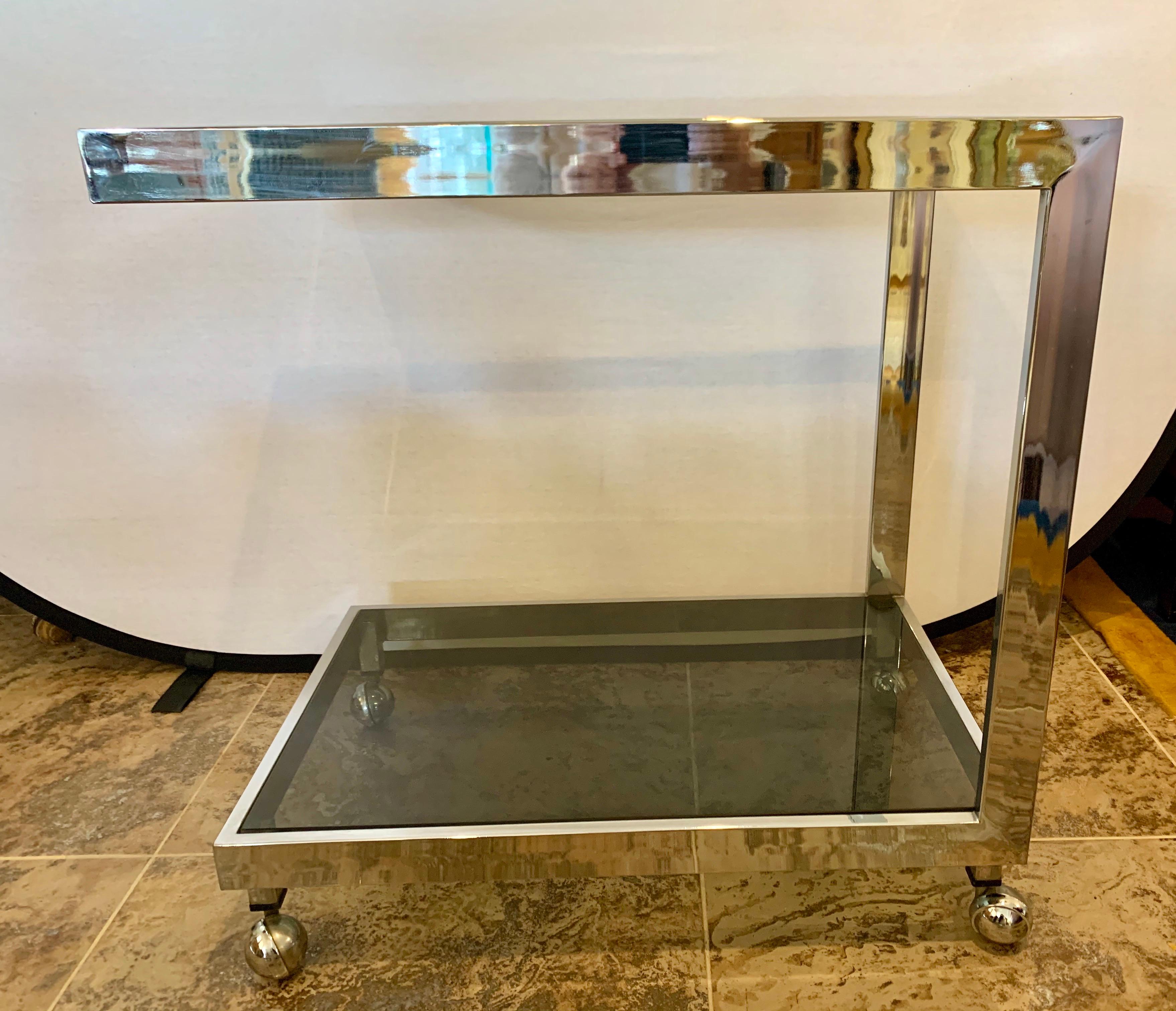 Iconic midcentury rolling bar cart with two tiers. The glass is smoked and the chrome is thick and gorgeous. Rolls as it should. One small chip at corner underside of glass that can't be seen.