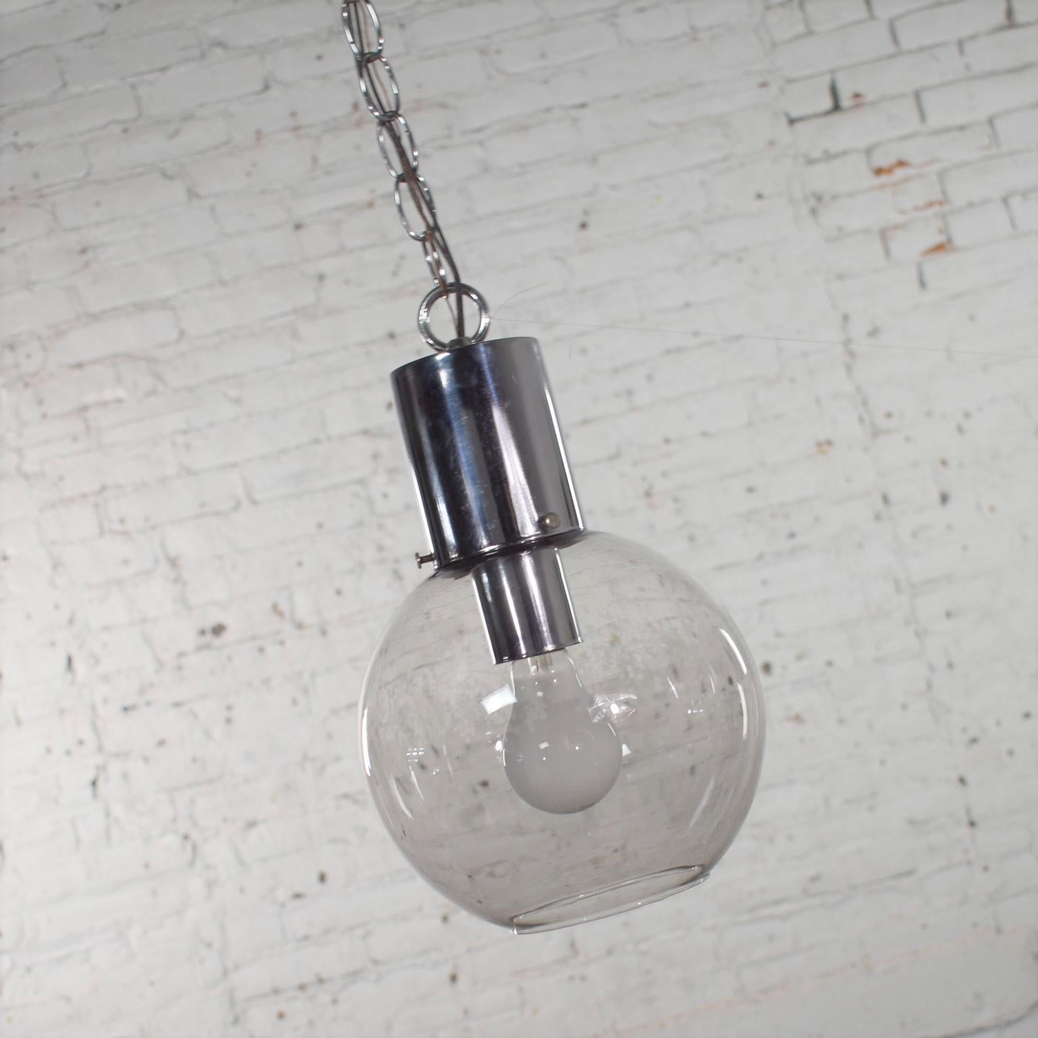 Handsome Mid-Century Modern chrome and lightly smoked glass open globe pendant light with chrome chain. It is in wonderful vintage condition with no outstanding flaws we have detected. Wiring has been checked and it is ready to hang. Please see