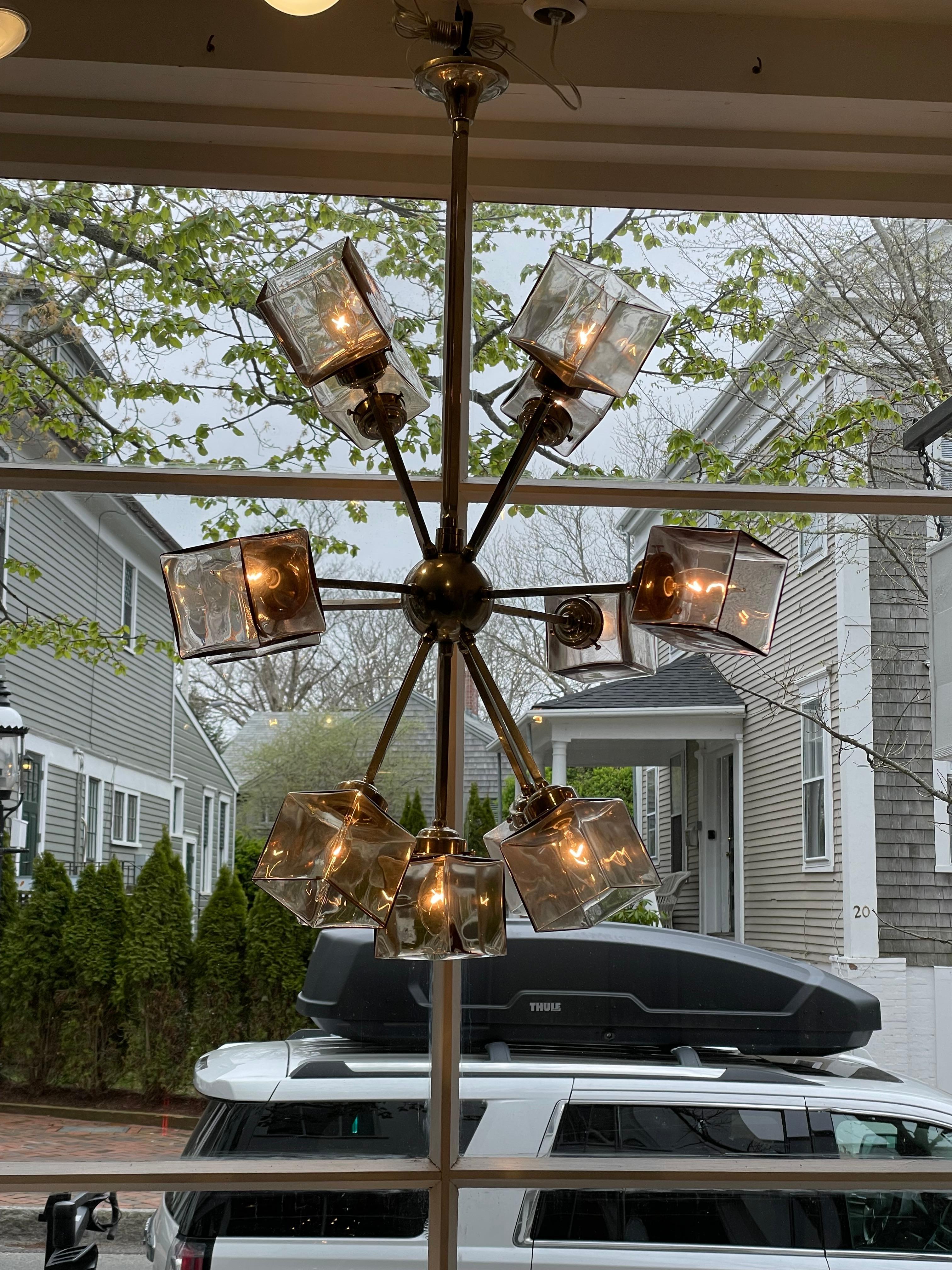 A stunning and unusual 1960's sputnik chandelier pendant light fixture.  Twelve-arm chrome fixture with square, smoked glass shades.  European fixture with the electrical components converted to American use. Takes candelabra base light bulbs, and