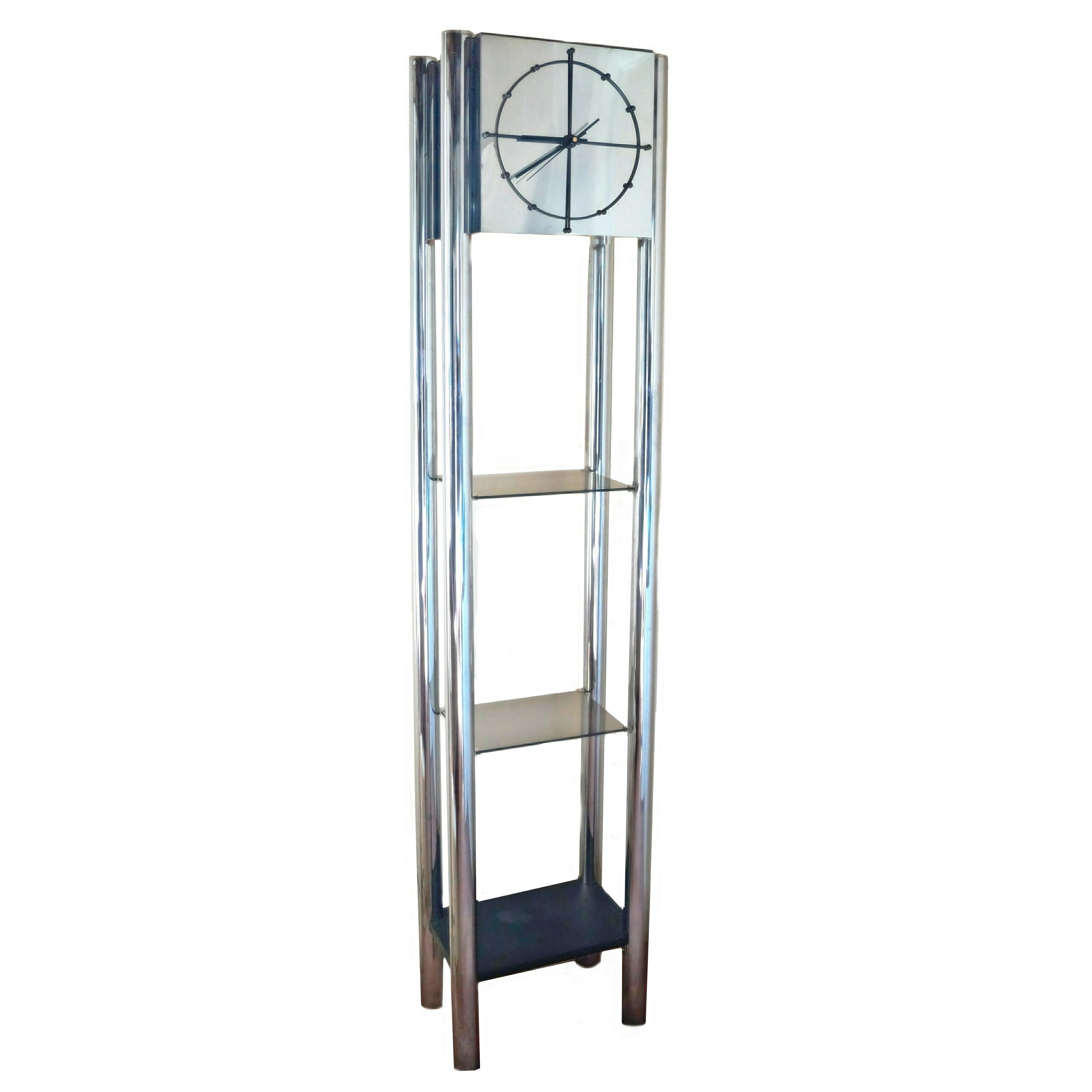 Modern chrome standing open grandfather fall clock étagère. This modern clock has three shelves, two in glass and the bottom is black. It has an inner downlight to highlight the glass shelves. The clock runs on battery. If you are in the New Jersey
