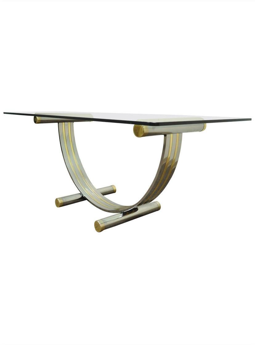 A Mid-Century arched chrome and brass table base attributed to Romeo Rega. This base can be used for a console table, or a dining table as it can support a large glass top. This base is not sold with a glass top. The base is in really good condition