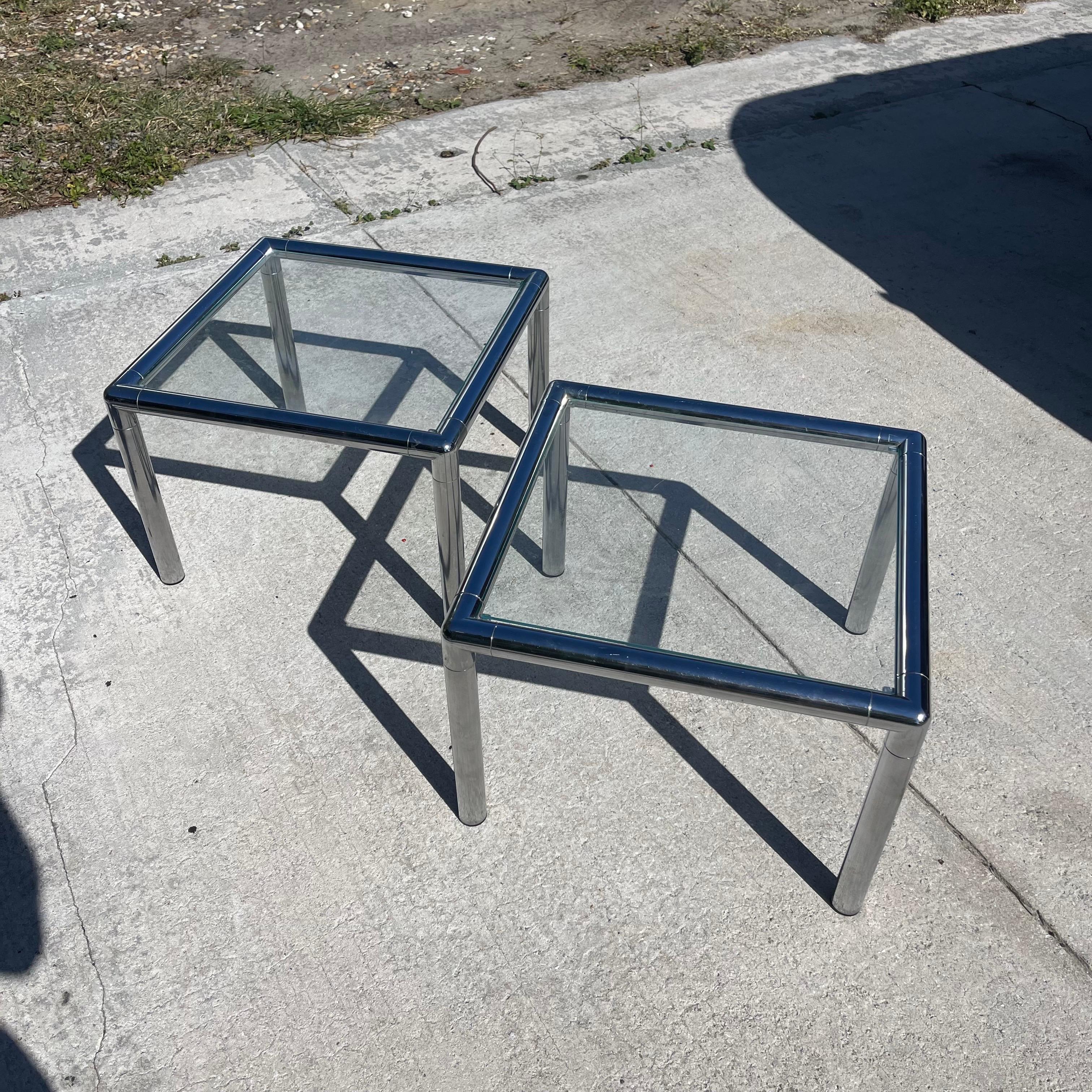 Fabulous pair of mid-century chrome tubular side tables with glass tops.