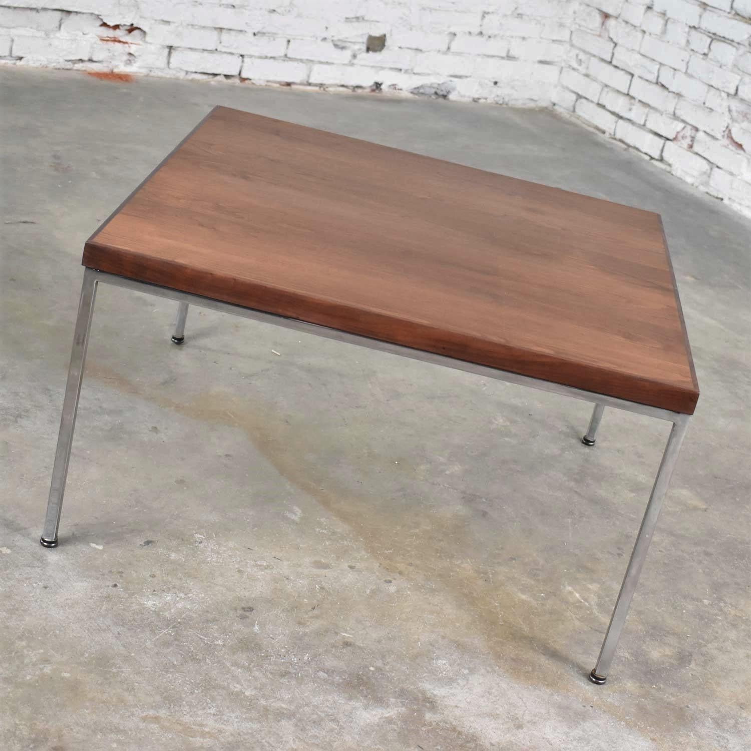 Handsome Mid-Century Modern end table or coffee table in walnut and chrome made in the style of Florence Knoll. It is in fabulous vintage condition with normal wear. The top has been restored; however, there are still visible signs of age and