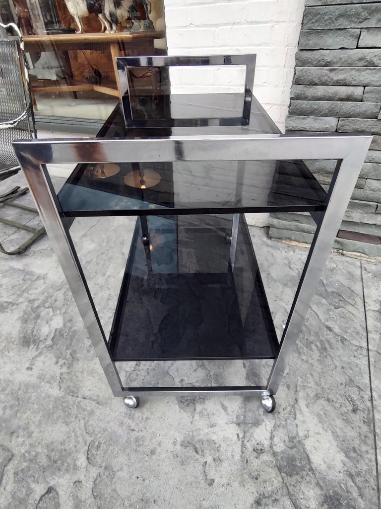 Simple and elegant chrome with black Glass bar cart. Clean straight lines keep it simple approach is the key to the design of this bar cart. Flat bars with chromed and rubber wheels, this cart has no issues with movement. Heavy thick 1/2 inch glass