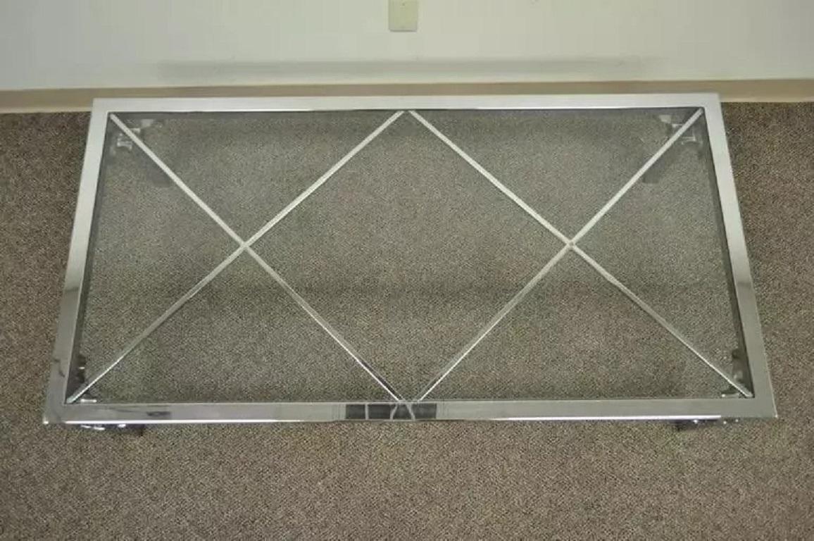 Table basse Vintage Mid Century Modern Chrome X-Frame Glass Top Hollywood Regency. L'article présente des joints polis sans soudure pour une esthétique globale plus nette. Chaque pied est orné d'un motif décoratif en forme d'arc de cercle dans