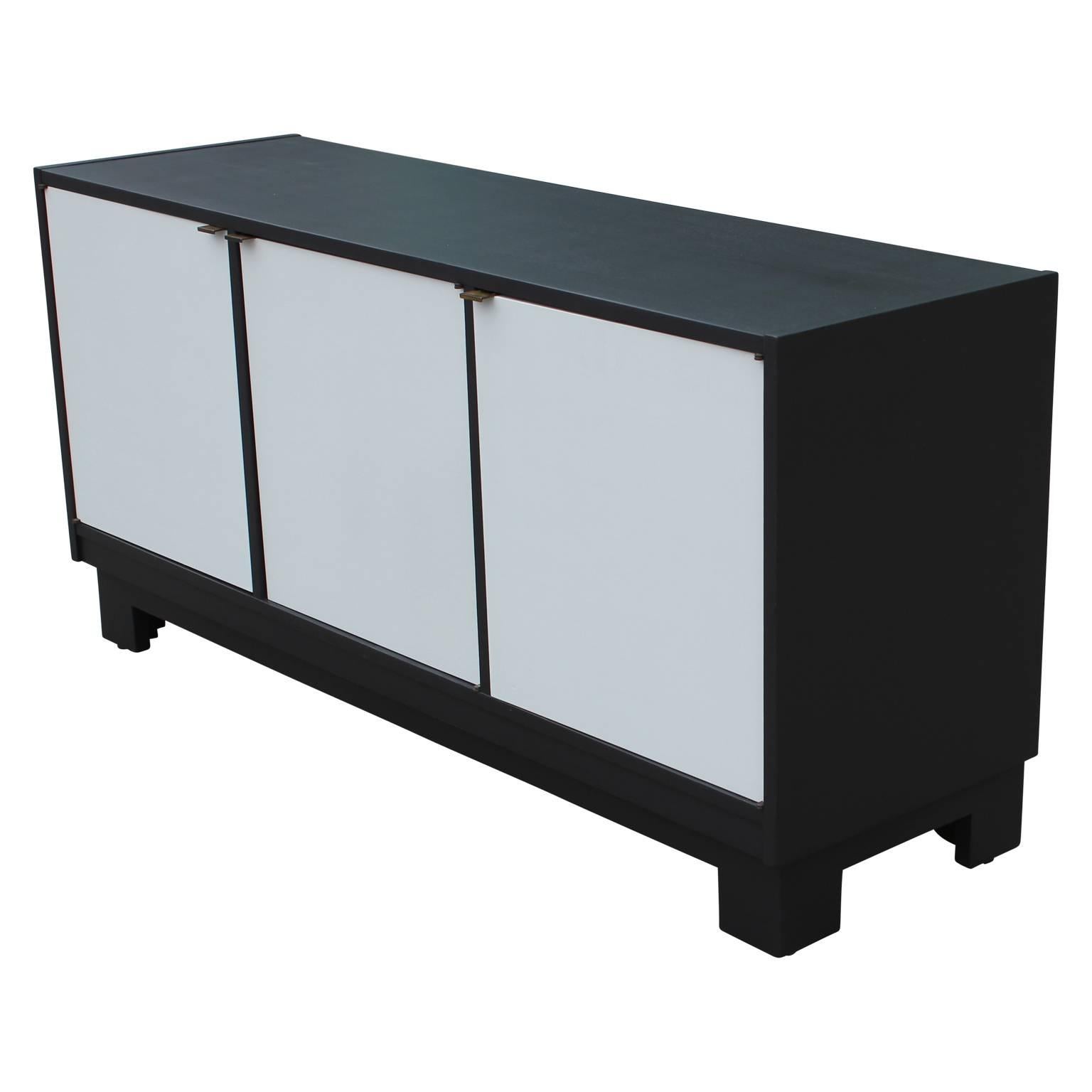 Modern Minimalist charcoal and grey credenza with brass hardware. The two left doors open to reveal single drawers with ample cabinet space below. The door on the right opens to show a single shelf.