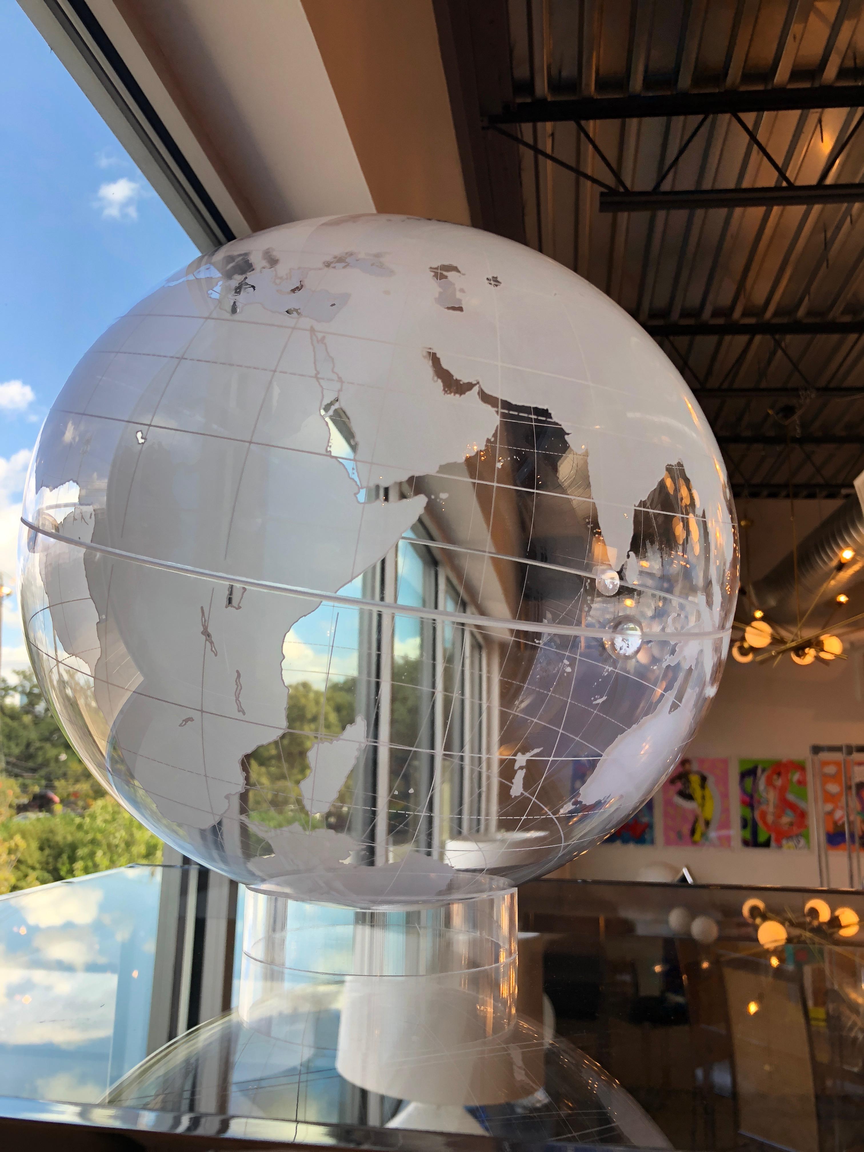 Offered is a Mid-Century Modern world globe with a clear background and frosted continents sitting atop a circular thick clear Lucite base. The globe has a smaller hole at the top in the event that the globe is hung. It is groovy man! What a great
