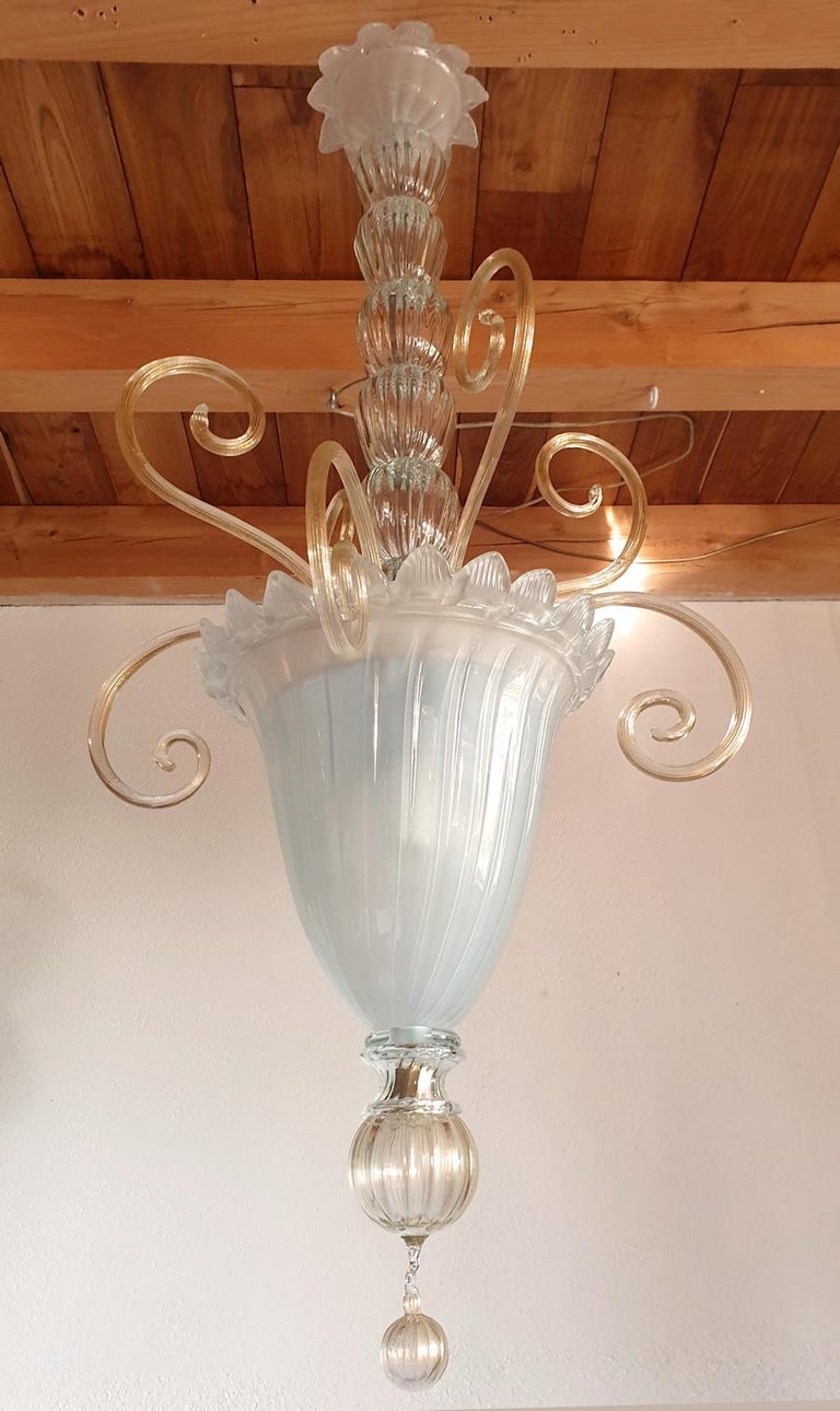 Tall hand blown vintage Murano glass lantern, or chandelier, attributed to Venini, Italy, 1960s.
The Mid-Century Modern lantern is made of a frosted glass translucent bottom vase, nesting 3 lights; clear glass and gold leaf ornaments.
Warm glow