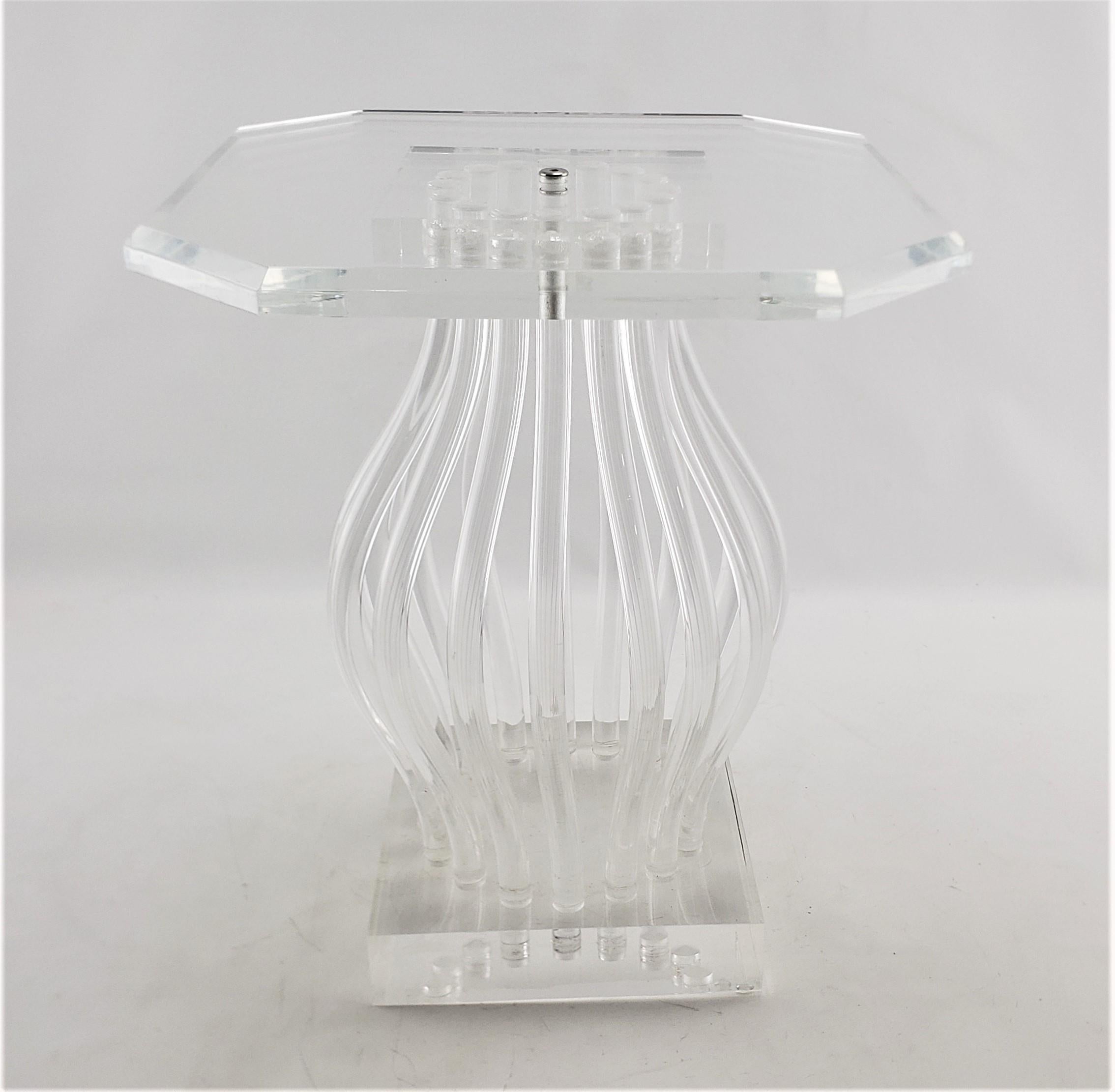 This clear lucite or acrylic and chrome 'Ghost' side table or pedestal is unsigned, but presumed to have originated from Italy, dating to approximately 1975 and done in a Mid-Century Modern style. The top is done with a clear beveled octagonal slab