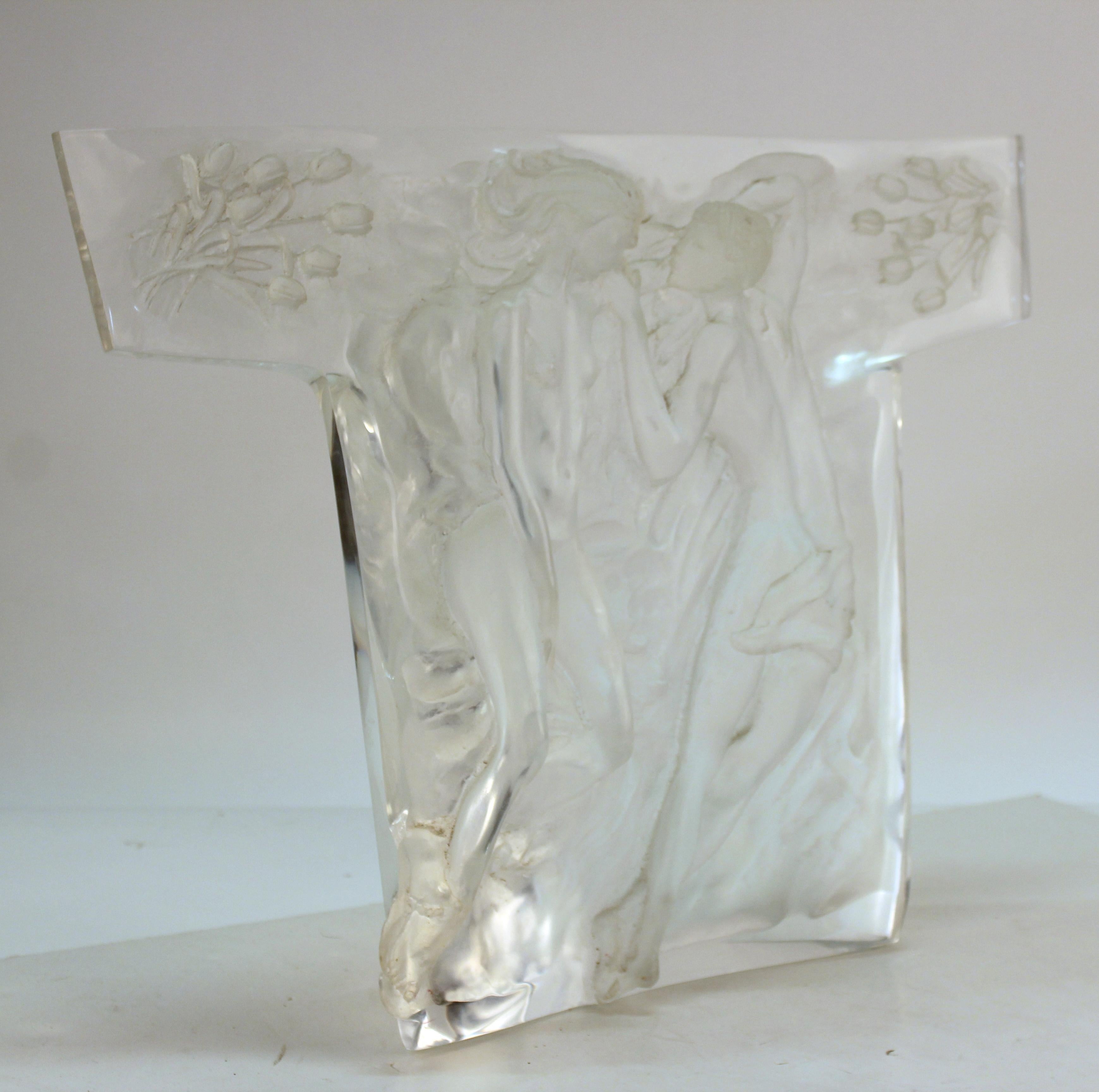 Mid-Century Modern relief sculpture of a couple of lovers surrounded by flora, cast in a T-shaped heavy translucent clear Lucite block. The piece dates from the mid-20th century and is in good vintage condition with minor age-appropriate wear to the