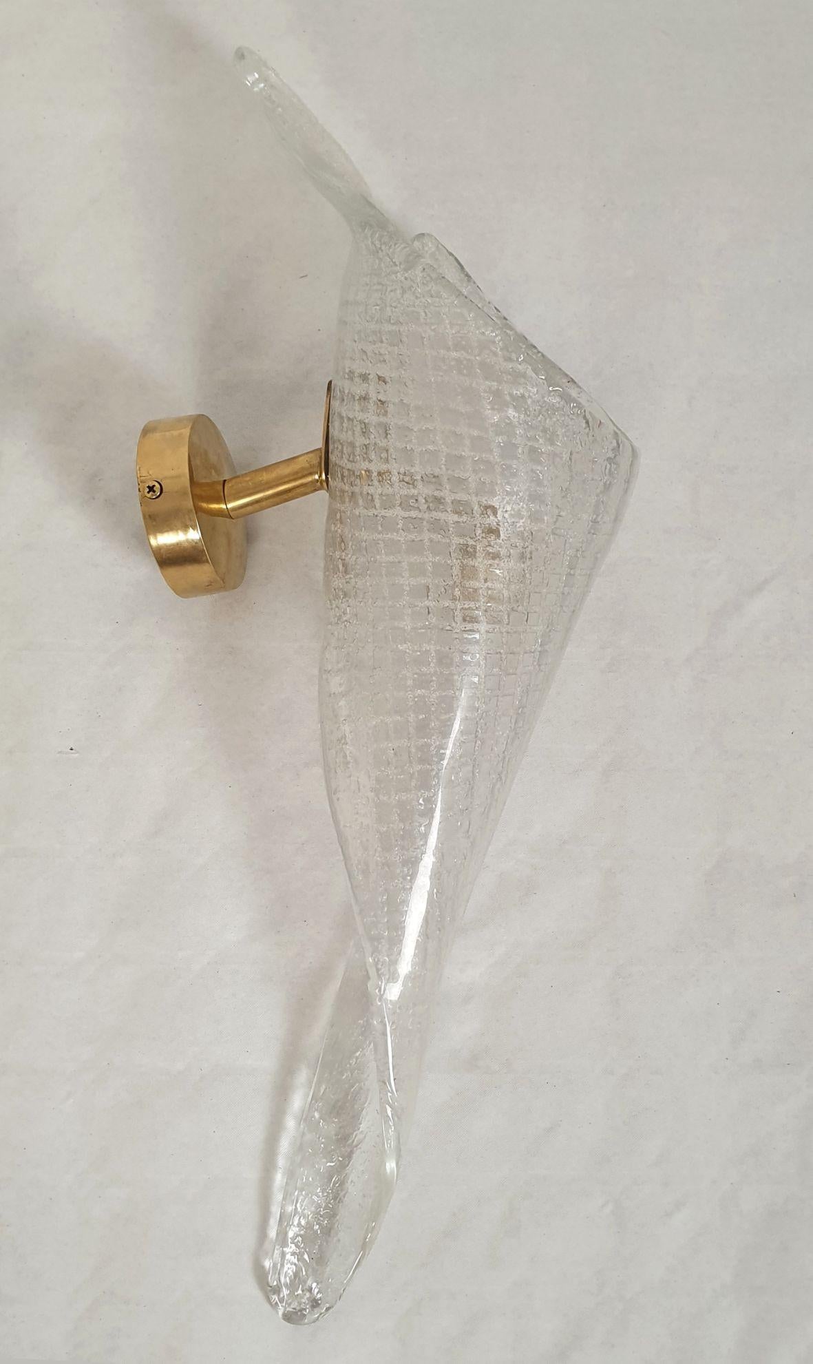 Pair of clear handmade Murano glass sconces, attributed to Seguso, Italy 1970s.
The Mid-Century sconces have brass mounts and a translucent twisted shape Murano glass shade.
The hand-blown and thick Murano glass has a grid pattern.
Each sconce has 1