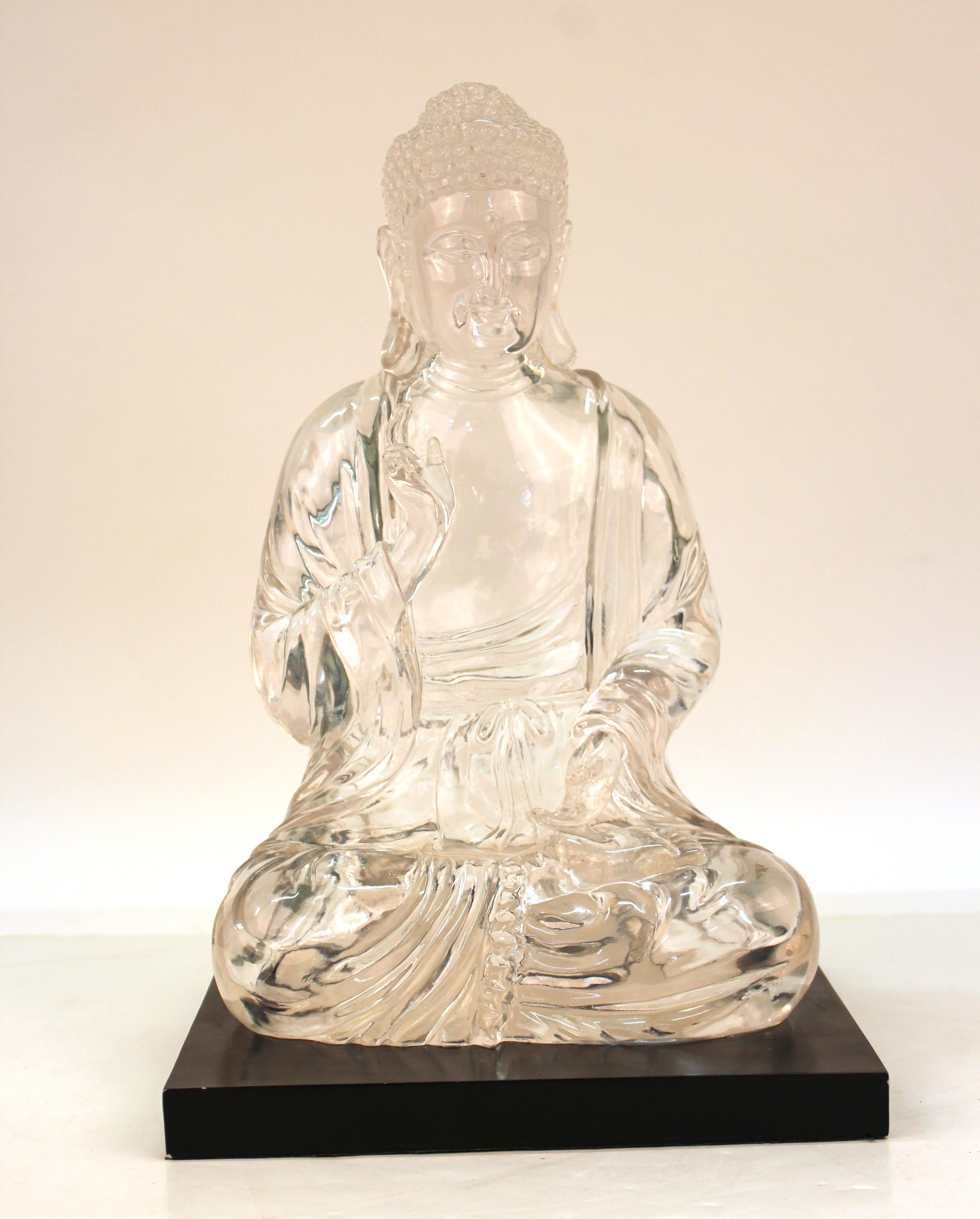 Mid-Century Modern statue of a Buddha in seated position, in clear resin atop a black base. The piece dates to the 1960s-1970s and is in great vintage condition. Age-appropriate wear to the base.