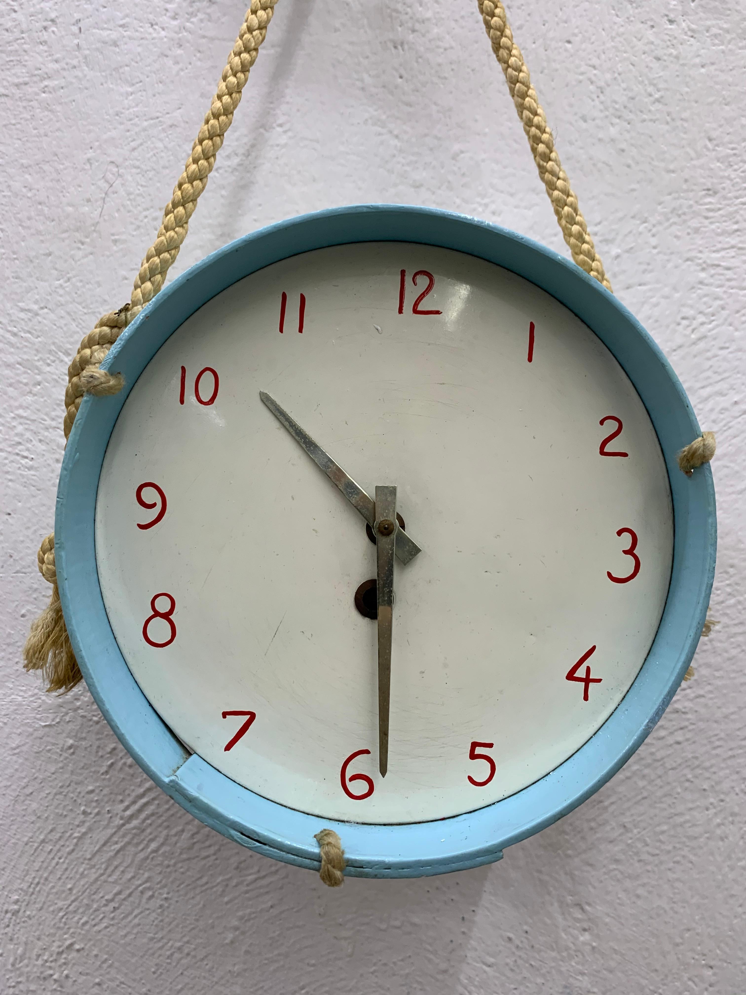 French mechanical clock, designed as a set of drums by Suzanne Bonnichon for Jacques Adnet, part of her line for children rooms' furnishing.
Manufactured in painted wood, brass, cord, and hand painted numerals, circa 1952.
Original wind-up key is
