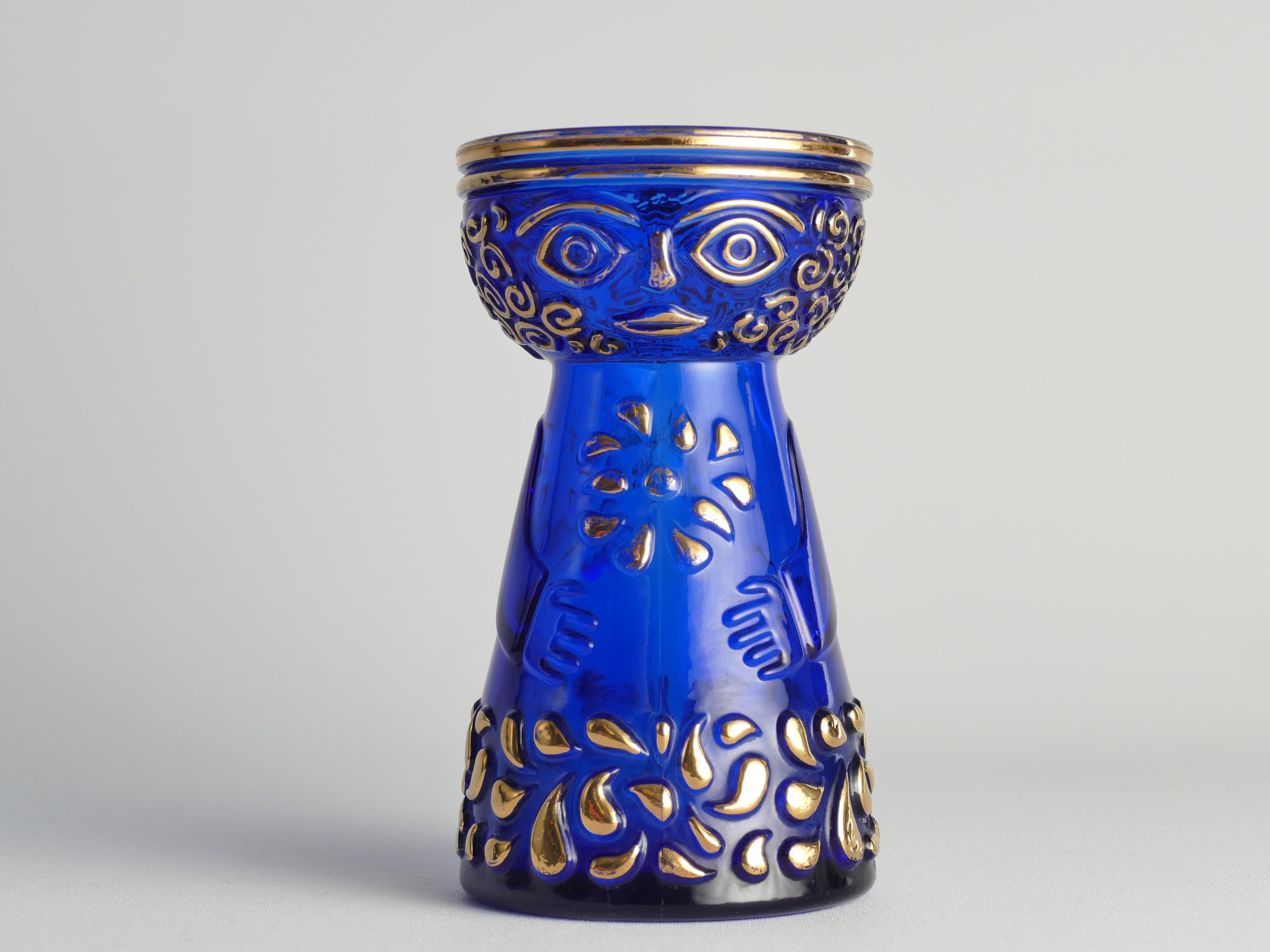 This mid-century modern cobalt blue vase with gold accents, this enchanting hyacinth vase originates from the 1970s and is a product of Walther Glas. Clearly influenced by the designs of Danish artist Björn Wiinblad, the vase takes the form of a