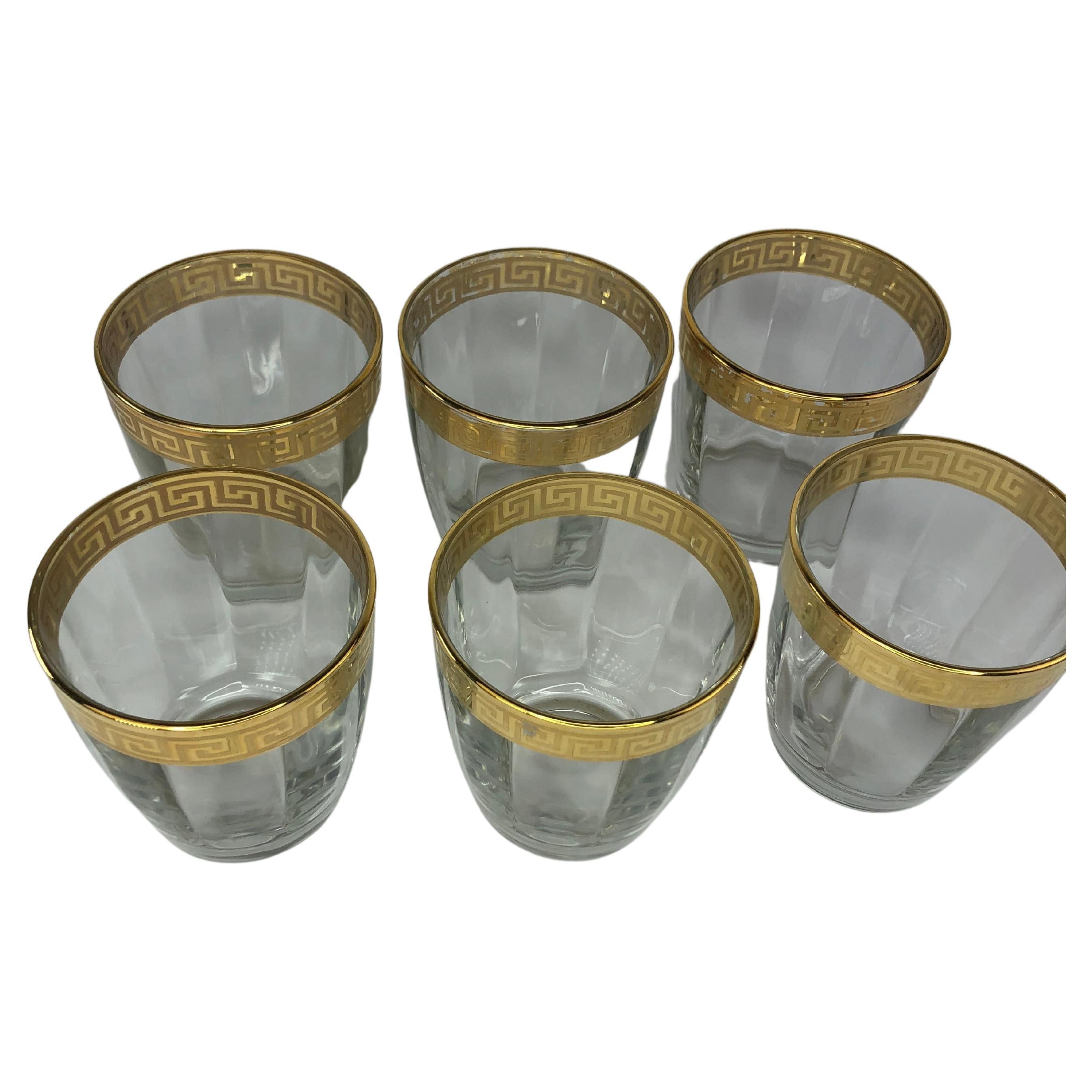 Mid-Century Modern gold banded cocktail glasses, set of six. This set of six rocks glasses is exceptionally elegant with the striking gold overlay Greek key design wide band at the lip of the glass. The glass has a vertical bevel making it even more